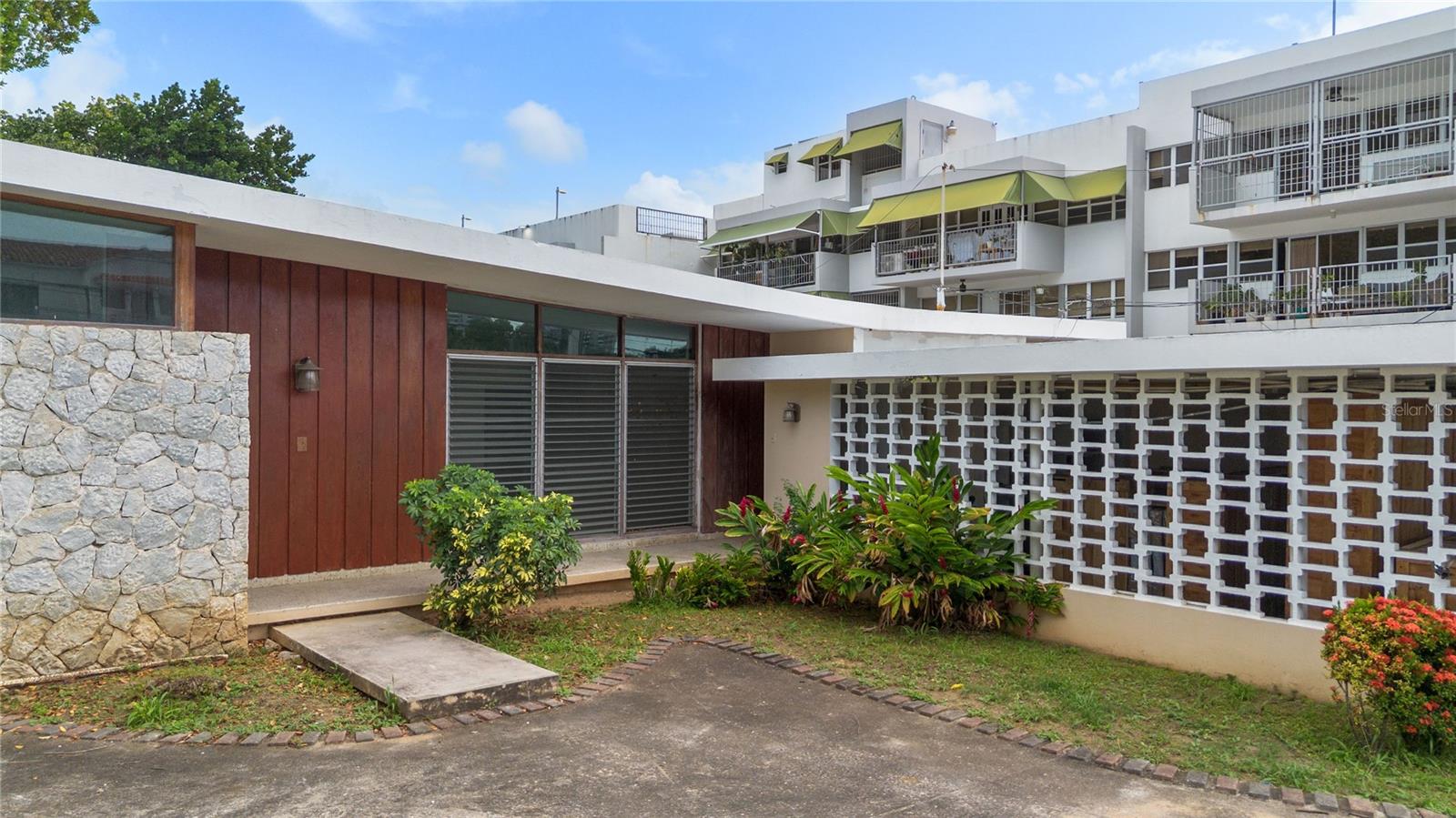 Presenting a truly unique opportunity to own a mid-century modern architectural residence nestled in the vibrant heart of Sagrado Corazon in San Juan. This distinguished ready-to-remodel home consisting of 4 bedrooms and 2-and-a-half baths, embodies the clean lines and timeless character of classic modernist design, showcasing striking angled rooflines, expansive geometric forms, and tasteful architectural detailing throughout.
Set on an oversized 1,008 square meter lot, the 2,383 sq ft. home offers not only immediate value but also tremendous potential for thoughtful renovation and expansion. Currently configured with 4 generously sized bedrooms and 2.5 well-proportioned bathrooms - including a functional Jack and Jill bath - this home provides an ideal foundation for modern living. Existing renovation and construction plans are already in motion, offering a clear vision for transformation while allowing new owners the flexibility to tailor the space to their personal taste and lifestyle.
The open layout includes a spacious living room and sunroom that floods the interior with natural light, an expansive kitchen footprint ready to be reimagined, and a full laundry room with direct access to the garage. One of the most exciting aspects of this property is its immense backyard - an unusually large outdoor space for an urban setting - brimming with potential to be converted into a private tropical oasis. Whether you're dreaming of a serene garden, a sparkling pool with outdoor living space, or a host’s paradise, the canvas is yours to create the ultimate retreat in the center of the city.
The home’s solid structure and exceptional lot size make it an outstanding investment opportunity for both homeowners and developers alike. With the possibility to open up interior walls, enhance natural flow, and add square footage, the property is ready for transformation into a truly extraordinary residence. Combining architectural significance, abundant space, and prime location, this mid-century modern fixer-upper represents one of the most compelling values currently available in San Juan. For buyers with a passion for design, this is your chance to elevate a remarkable home into a modern masterpiece.