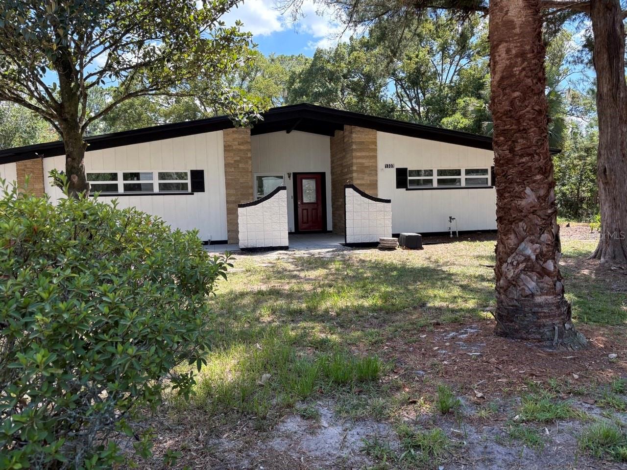Beautifully updated 3-bedroom, 2-bath concrete block home offering over 1,700 square feet of living space. Recent renovations include a fully remodeled kitchen with brand-new appliances, high-end vinyl flooring throughout, and soaring cathedral ceilings that create a bright and open atmosphere. An extended sliding glass door provides abundant natural light and easy access to the spacious backyard. The primary suite features a new walk-in shower, while the home is further enhanced with a brand-new roof for peace of mind. Outdoor living is a highlight with a covered porch and awning—perfect for summer cookouts or relaxing with friends. Situated on a generous lot in a quiet Gainesville neighborhood, this property combines modern upgrades with a comfortable, functional layout.