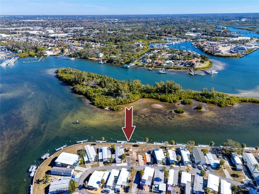A truly rare opportunity to build a custom waterfront home in a resident-owned 55+ cooperative community tucked along the tranquil waters of Tarpon Bayou, offering direct Gulf access with no fixed bridges. This vacant, build-ready waterfront lot includes a 30-foot private boat slip (a significant included value) and utilities already in place, making it ideal for buyers seeking a seamless path to creating a custom manufactured or mobile home that aligns with the attractive, well-maintained homes throughout the community. An elevated or thoughtfully designed new home here would enjoy constant waterfront activity, from dolphins and manatees gliding past to stunning sunset views and refreshing coastal breezes. Ownership includes a share in the cooperative, providing stability, pride of ownership, and access to seven-plus acres of water-surrounded grounds, a community dock, kayak launch, shuffleboard courts, and a welcoming clubhouse that hosts frequent social gatherings. Boating enthusiasts will appreciate being able to step from home to boat and cruise directly to the Anclote River, the historic Tarpon Springs Sponge Docks, Anclote Island, and Three Rooker Island, while anglers can fish right from the docks for snook, redfish, and trout. The community allows up to two small pets and permits one-month minimum rentals, offering flexibility for seasonal residents or extended-stay use. Just minutes away, Tarpon Springs delivers a vibrant coastal lifestyle with waterfront dining, authentic Greek cuisine, boutique shopping, First Friday events, the Pinellas Trail, Fred Howard Park, Sunset Beach, and nearby Gulf beaches. Vacant waterfront lots with included boat slips in established 55+ co-op communities are extremely limited in Pinellas County, making this a standout opportunity for buyers seeking affordable Gulf-access living and the freedom to build a personalized waterfront retreat in one of Tarpon Springs’ most charming and sought-after settings.