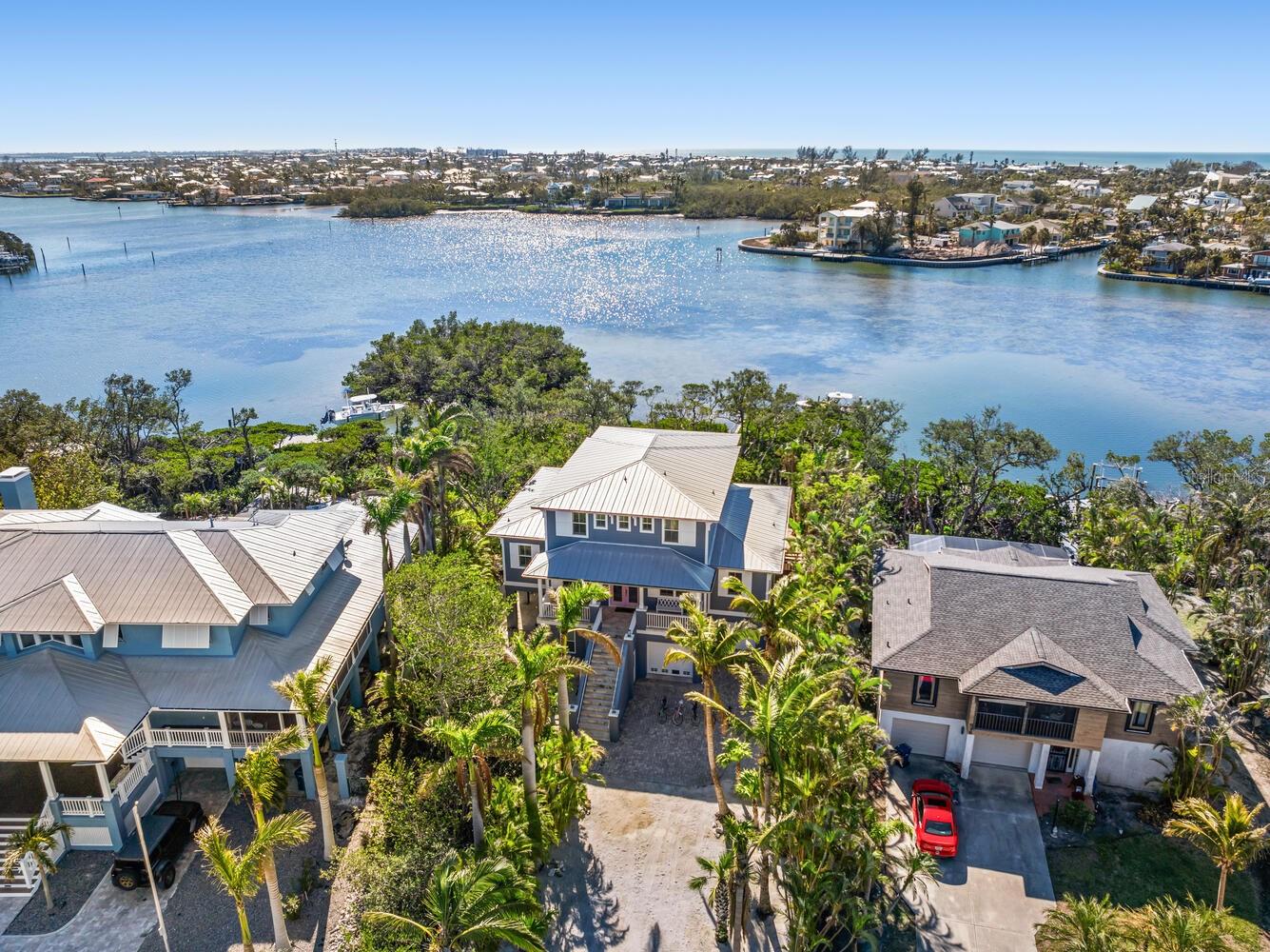 Quick question before you read on…. Are you here for business, pleasure or a little of both? We ask because 517 Blue Heron is built and ready for all of the above! We challenge you to find a better performing asset on the island which can provide you actual rental history and income and NOT a management company’s sales pitch of pro-forma capability. Welcome to a truly rare waterfront gem on Anna Maria Island. This high-performing short-term rental generates nearly $200K annually while doubling as the perfect vacation retreat for you personally. Located on spacious open water—far superior to a canal—this 4-bed, 4-bath, 3,000+ sq. ft. home offers unparalleled water views and a 12,000 lb boat lift with dock (currently holding a 27’ center console) with no bridges between you and open water. Can you picture starting your morning off with a sunrise paddle board session? The resort-style outdoor spaces feature a heated pool, hot tub, grill, and covered dining area, all tucked away on a quiet cul-de-sac with no road noise. Enjoy the charm of Old Florida with modern luxury and the best of both investment and lifestyle in this island paradise!
