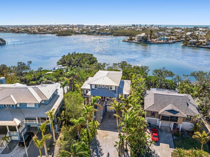 Quick question before you read on…. Are you here for business, pleasure or a little of both?  We ask because 517 Blue Heron is built and ready for all of the above! We challenge you to find a better performing asset on the island which can provide you actual rental history and income and NOT a management company’s sales pitch of pro-forma capability. Welcome to a truly rare waterfront gem on Anna Maria Island. This high-performing short-term rental generates nearly $200K annually while doubling as the perfect vacation retreat for you personally. Located on spacious open water—far superior to a canal—this 4-bed, 4-bath, 3,000+ sq. ft. home offers unparalleled water views and a 12,000 lb boat lift with dock (currently holding a 27’ center console) with no bridges between you and open water. Can you picture starting your morning off with a sunrise paddle board session? The resort-style outdoor spaces feature a heated pool, hot tub, grill, and covered dining area, all tucked away on a quiet cul-de-sac with no road noise. Enjoy the charm of Old Florida with modern luxury and the best of both investment and lifestyle in this island paradise!