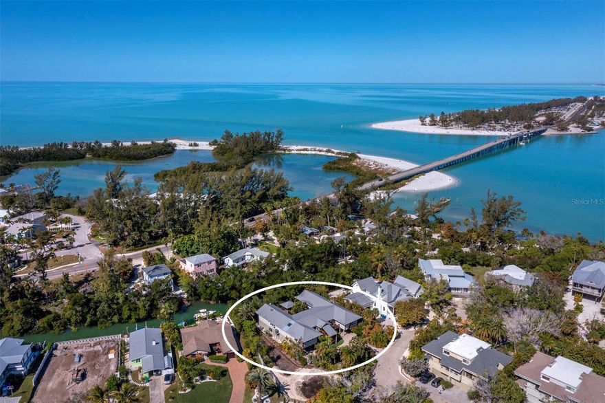 In a rich tropical waterfront setting on Longboat Key, this unique retreat lives like a modern treehouse while evoking a sense of peace, family and comfortable, easy island living. Tucked within the island’s native landscape along a natural bayou off Sarasota Bay, the property offers a rare opportunity to experience serene waterfront living surrounded by nature, with the Gulf’s azure waters and pristine beach access just moments away. Enjoy your private backyard dock and kayak launch or secure your boat on one of the deepwater slips on the open bay. Excellent fishing and bird watching await right outside your door in this remarkable natural habitat. The spacious home is anchored by a stunning great room with vaulted cedar ceilings and exposed beams. The home features a 40-by-9-foot sunroom with bar area and handcrafted art shelves, a dedicated library, an inviting family room and a separate private office with extensive built-in cabinetry, providing warmth and functionality. Extensive decking spans the front entry and wraps around an inner atrium courtyard for alfresco dining. An elevated cabana-style shaded area invites relaxation in sun and shade. The kitchen with center island is positioned for hosting memorable gatherings. The primary suite offers a full wall of windows overlooking the tranquil bayou, two walk-in closets and an additional wall of custom storage. The split floor plan provides a separate wing for guests, featuring two additional bedrooms and baths for convenient hosting. Each guest room offers private access to the outdoor decks and views of the tropical center atrium. Two garages accommodate up to four vehicles, boats, golf carts or paddleboards. Many of the furnishings are included. In Land’s End, an intimate gated community of just 12 residences, owners enjoy maintenance-free landscaping, a heated pool, tennis and pickleball courts, and convenient deepwater boat slips, all artfully tucked among the trees for privacy. From here, it is a short visit or golf cart ride to the captivating sandy Gulf beach or local favorites, including Shore Longboat Key, Mar Vista Dockside Restaurant and Whitney’s. The adjacent plaza also offers multiple popular waterfront cafes, boutique shops, Ventura’s restaurant, and 24/7 gym or Pilates studio. Enjoy mesmerizing sunsets on the Gulf or sunrises on the bay from this waterside community. This is a rare offering in today’s marketplace, capturing the allure of Old Florida living in one of the island’s treasured enclaves.