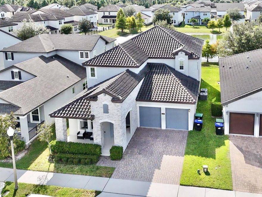 Experience the elegance of Westside Village in Windermere, where timeless design meets modern luxury. This five-bedroom, four-bath residence spans 3,717 square feet of thoughtfully designed living space, built in 2018. The foyer welcomes you with porcelain tile floors, vaulted ceilings, and chandelier lighting that set a tone of quiet sophistication. French doors open to a versatile home office, while the formal dining room with tray ceiling creates the perfect setting for gatherings. The open-concept great room connects seamlessly to the chef's kitchen featuring a butler's pantry, premium finishes, and expansive sightlines. Enjoy peaceful water and fountain views, or open the sliding glass doors to the covered lanai, ideal for relaxing under the Disney fireworks. The owner's suite offers a serene retreat with natural light, spa-inspired bath with soaking tub, dual vanities, and a spacious walk-in closet. Upstairs, a generous loft provides flexible living for media, games, or study, while each bedroom includes a walk-in closet with a private sink. Designed for efficiency and comfort, this home features dual AC systems, a whole-house dehumidifier, and dual-pane storm windows. Residents enjoy resort-style amenities a community pool, walking trails, and parks within the sought-after Windermere school district, just minutes from dining, shopping, and Disney.