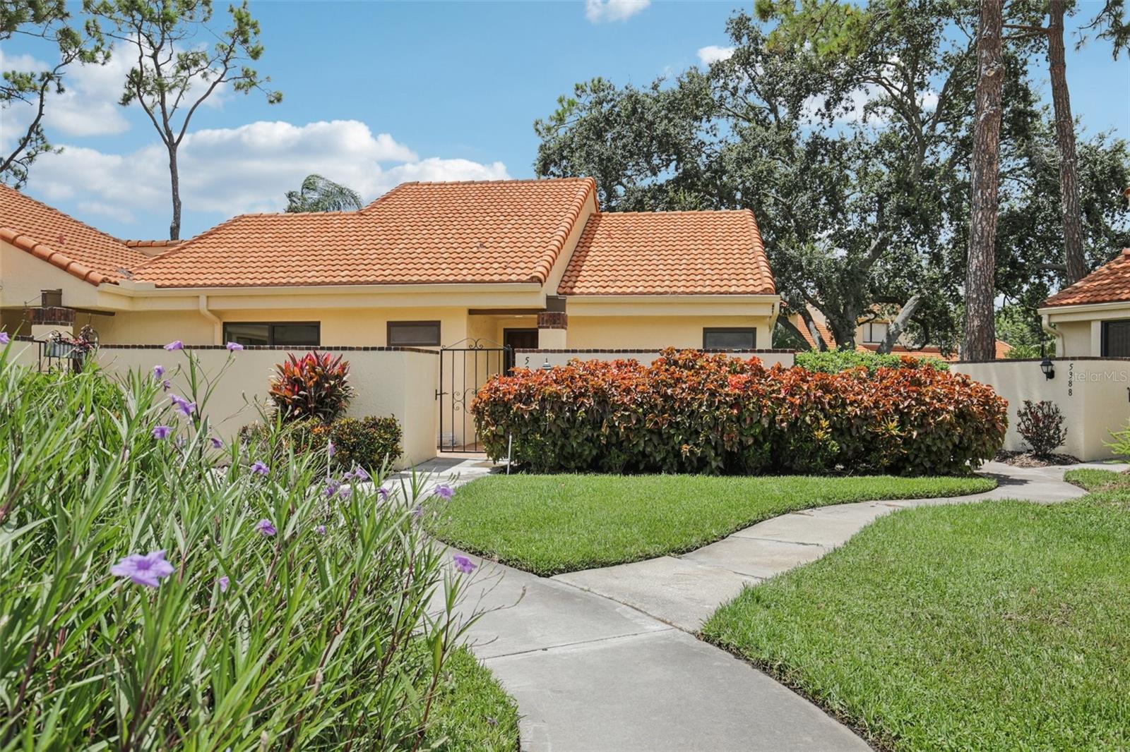 Stylishly Renovated 2-Bedroom, 2-Bath Villa in The Meadows – Light-Filled & Move-In Ready! Welcome to this beautifully updated 2-bedroom, 2-bath villa in the highly sought-after Meadows community, where soaring vaulted ceilings, abundant natural light, and a clean, modern aesthetic set the tone for relaxed Florida living. Freshly updated laminate wood flooring runs throughout the entire home, complementing the open-concept layout designed for effortless indoor-outdoor flow. The renovated kitchen is both functional and inviting, featuring refreshed cabinetry, expansive countertops, a double sink, and stainless steel appliances—perfect for daily cooking or entertaining guests. A raised dining area adds architectural interest and versatility to the main living space. Step outside to discover the home’s true sanctuary—an enchanting screened lanai with a rustic beamed ceiling and cooling fan, perfect for year-round enjoyment. Surrounding the home, a wraparound garden patio offers multiple tranquil spots to relax, read, or soak in the Florida sunshine, all accessible through sliding glass doors from both the living room and bedrooms. The thoughtful split-bedroom layout ensures privacy for owners and guests alike, while both bathrooms have been tastefully updated. The primary suite features dual vanities, a spacious walk-in shower, and generous closet space for comfort and convenience. Tucked within a well-maintained, amenity-rich community, this move-in-ready villa is ideal as a full-time residence or seasonal retreat—perfectly located in the heart of Sarasota near golf, shopping, dining, parks, and Gulf beaches.