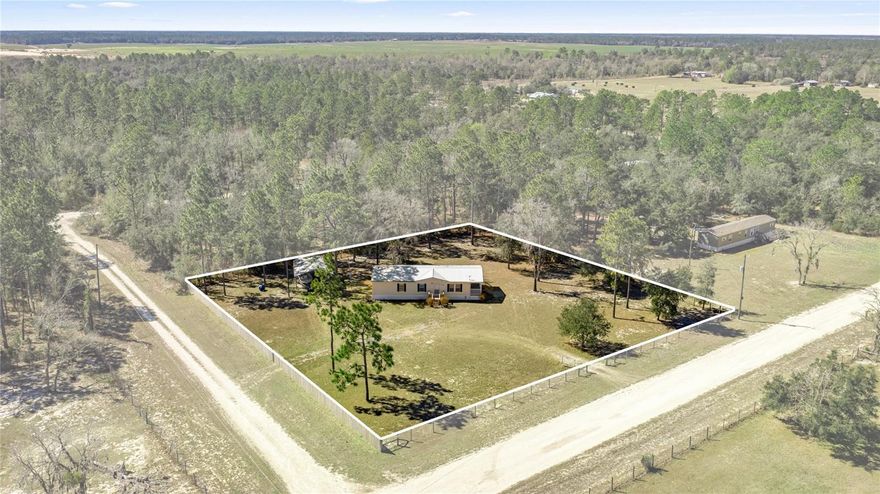 FULLY FURNISHED and MOVE-IN READY! Nestled on a secluded 1-acre picturesque corner lot, this charming 2006 Fleetwood 3 Bedroom/2 Bath Double Wide Home offers the perfect blend of comfort and country charm. Zoned Agricultural/Rural Residential. NO HOA & NO Flood Zone! Located between Gainesville and Dunnellon and a 30-minute drive from Ocala and the World Equestrian Center. The home is well protected with a durable metal roof and a fully fenced perimeter, offering added security, privacy, and peace of mind. Step into a cozy and inviting living space where warm finishes and volume ceilings create an airy, open feel with plenty of natural light. The equipped kitchen offers; newer appliances, ample cabinetry, and inside laundry. Master suite and ensuite offer two separate walk-in closets, step-in shower, and dual vanity sinks. Step outside and enjoy glorious sunsets and nature views from your porch. Expansive yard perfect for family fun, entertaining guests, and furry friends to roam freely. The 20x31 metal utility building, includes a 6x6 roll up door combined with an enclosed storage section to house your vehicles, tools and lawn equipment. Whether you’re looking for peaceful mornings, a retreat property, room for your RV, boat, camper or travel trailer, this homestead delivers. Upgrades include; HVAC 2019, Metal Roof 2020, Carport/Shed 2020, Wood Steps 2024, and Privacy Fence 2025. Bring your animals, your toys, and your vision, there’s room for it all. Your slice of the countryside awaits away from it all but close to everything!