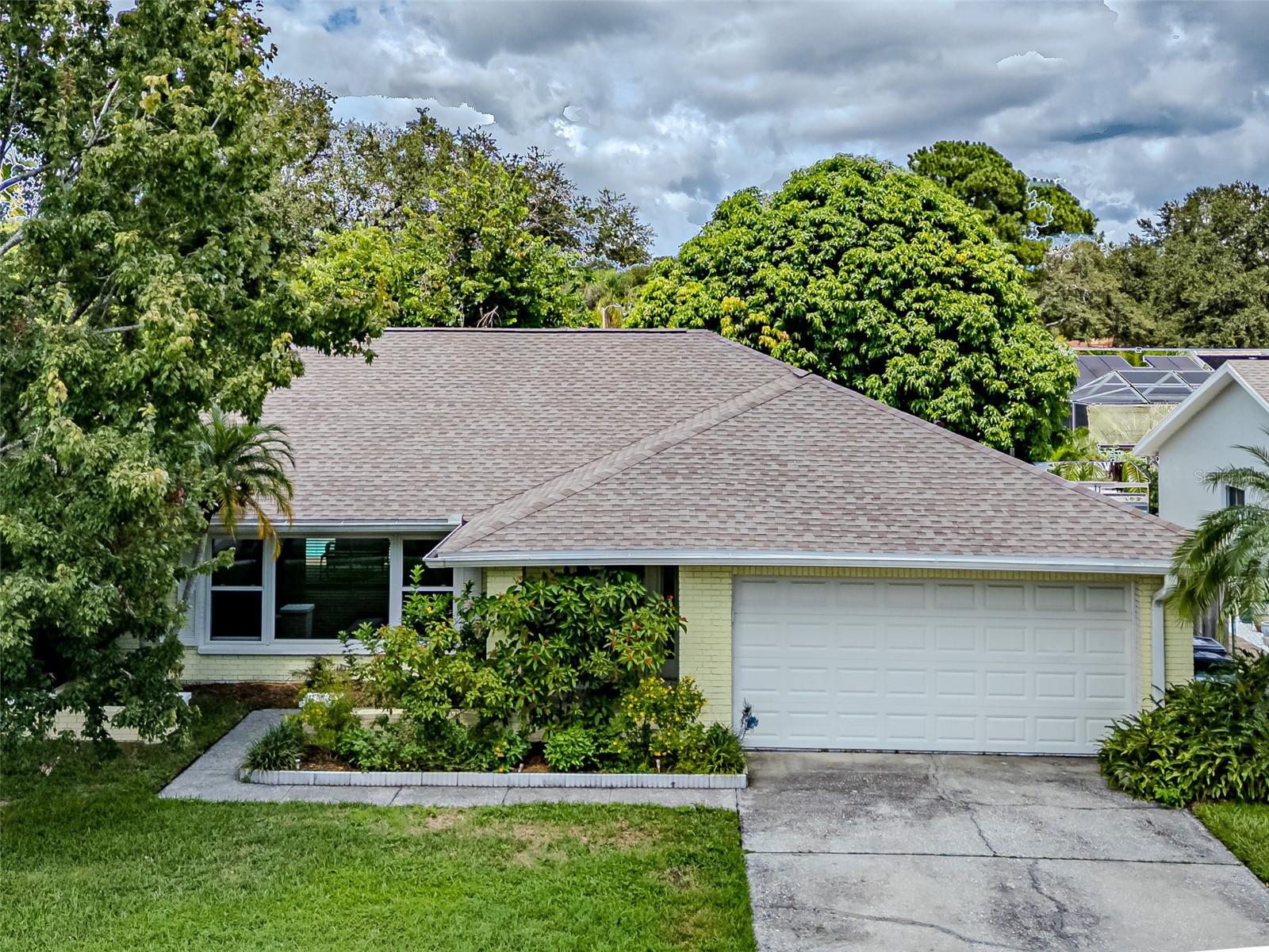One or more photo(s) has been virtually staged. Nestled in the heart of charming Safety Harbor, this beautifully maintained home offers unbeatable convenience and comfort. Located just minutes from major shopping centers, popular restaurants, waterfront parks, and playgrounds, you'll enjoy easy access to everything this vibrant community has to offer. Whether you prefer a relaxing stroll or a quick golf cart ride, downtown Safety Harbor is just around the corner—home to an array of unique boutiques, local eateries, and year-round events. The home boasts significant recent improvements, including a brand-new roof in 2024 with SWR membrane plus 3-nail hurricane clips and a new A/C system installed in 2025, offering peace of mind and energy efficiency. Imported Italian Ceramic tile was added throughout the house in 2019. An updated master bathroom features elegant marble tile flooring, dual undermount sinks set in a marble countertop, and rich wood cabinetry. A glass-walled shower with a sliding door and decorative Listello tile adds a spa-like feel to the space. The second bathroom was also tastefully updated in 2019 with quartz countertops, dual sinks, wood cabinetry, and a new toilet—perfect for both family living and entertaining guests. As the center of the home, new additions to the kitchen like a new sink, faucet and disposal in 2025 as well as a new dishwasher in May of 2024 were pretty significant upgrades. With a breakfast bar and pass through window out to the oversized lanai, this area is the perfect focal point for family and friends. Access to the lanai and oversized pool is available from several points of the home, including the Master suite area. What lies beyond the pool, is a lush oasis of fruit trees and Florida plants. All of the back yard is enclosed with wood fencing put in by this owner. This move-in-ready home is the perfect blend of style, comfort, and location.