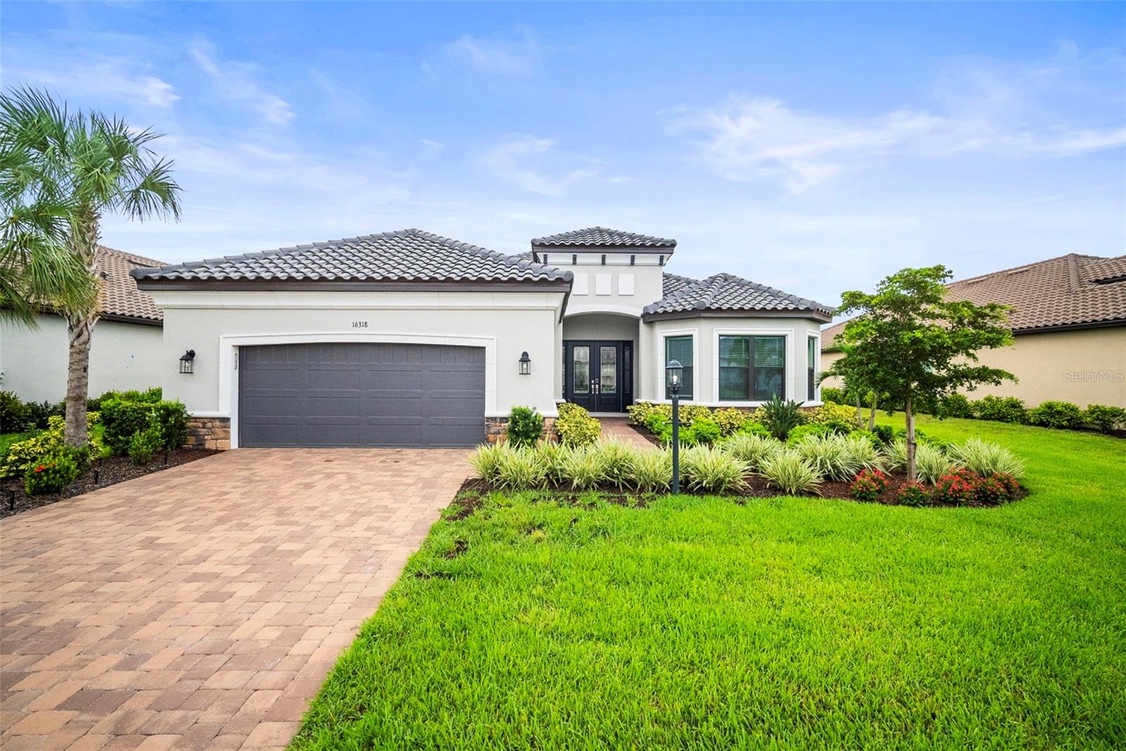 Welcome to an exceptional blend of elegance and modern convenience in this 2024-built home, perfectly situated in the exclusive Esplanade at Azario community in Lakewood Ranch--an amenity rich championship golf course community. This stunning residence, which has IMPACT WINDOWS AND DOORS, offers a private and comfortable lifestyle with three bedroom three bathrooms, a dedicated den/office, and a rare tandem three-car garage. Step inside and be greeted by a refined ambiance with porcelain plank tile, soaring tray ceilings with crown molding and custom lighting/fans throughout. The second bedroom includes its own en-suite bathroom, providing ultimate privacy for family or guests. The master bedroom and third bedroom feature charming bay windows, which flood the rooms with natural light. The great room has a custom, acoustical feature wall to help enhance your sound quality experience. The home's interior is elevated by 10-foot ceilings, 8-foot, solid core doors, double, stacking sliders in the great room and kitchen, soft-close, upgraded cabinetry and quartz countertops in kitchen and bathrooms. The gourmet kitchen, with extended casual dining, is a chef's dream, complete with quartz countertops, upgraded GE Cafe appliances, a large island and designer plumbing fixtures. Relax and unwind in your private, oversized screened-in lanai with pool, which features a built-in outdoor kitchen. Ceiling fans are installed in the lanai to ensure year-round comfort. The tandem three-car garage provides ample space for extra storage, a workshop or gym. Living in Esplanade Azario means you have access to a resort-style lifestyle right outside your door. The community offers a championship 18-hole golf course with an on-site pro shop, a gate entrance for enhance security, an elegant clubhouse with a breakfast bar, resort-style pool, full-service spa, state-of-the art fitness center, a poolside Bahama Bar and a full-time Lifestyle/Activity Manager to plan community events. The Culinary Center is 'awesome', with a fine dining restaurant, bar, casual dining, wine lockers and a culinary teaching kitchen. There are 16 pickleball courts, tennis and bocce. Although this home isn't "golf deeded", you can still pay-to-play on the championship golf course. The amount of clubs and activities means you'll meet tons of new friends and never run out of fun events!