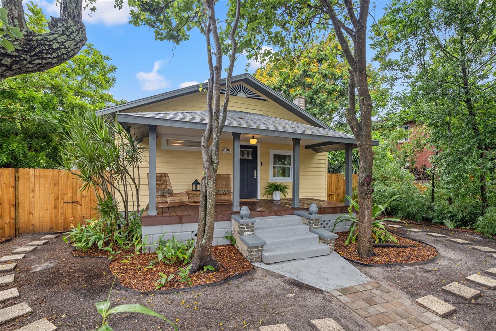 Nestled in the heart of Historic Kenwood, this bungalow with a detached in-law suite has been beautifully restored all while keeping its original charm. The main bungalow has 2 bedrooms and 2 bathrooms with over 1,000 sqft of living space. The eat-in kitchen offers shaker cabinets, topped with granite countertops and stainless steel appliances. The kitchen offers plenty of countertop space for cooking prep and has floating shelving flanking the kitchen sink window. Adjacent to the kitchen is a formal dining space that has French doors leading out to a side porch. The living room is large inside and looks out over the front porch. It has plenty of space for a sectional and has a fireplace with brick detailing that brings a cozy vibe to the space. The original wood flooring has been fully restored, giving the home a fresh feel while preserving that historic charm. The primary suite is located privately in the back of the home with an ensuite bath complete with a walk-in tiled shower and double vanity sink. The second bedroom is located towards the front of the home with a guest bathroom that is located centrally to the rest of the home. The main home has a private yard with a paver patio and astroturf for easy maintenance. The back in-law suite has a private entrance complete with 1 bedroom and 1 bathroom with a living and dining space and spacious kitchen. The kitchen has all the needed appliances with shaker cabinets and granite countertops. This space would be perfect for personal use or additional income. The home has plenty of off street parking in the back and is located in a non-flood zone. Sought after Historic Kenwood is a diverse, artsy district known for its mature oak trees, brick streets, and high concentration of Craftsman Bungalows. The Sunday Market is located across the street from the home where you can find local produce, flowers, shops and food stands. Popular local restaurants, cafes, bars, and boutiques line busy Central Avenue just a few blocks away, perfect for day and nighttime entertainment. The neighborhood is just 10 minutes to Downtown St. Pete where you can find fine dining options and high end shops. The St. Pete Pier is also located Downtown and is just a 15 minute bike ride away. The neighborhood is also conveniently located close to the highway making commuting easy and travel to and from Tampa a breeze.
