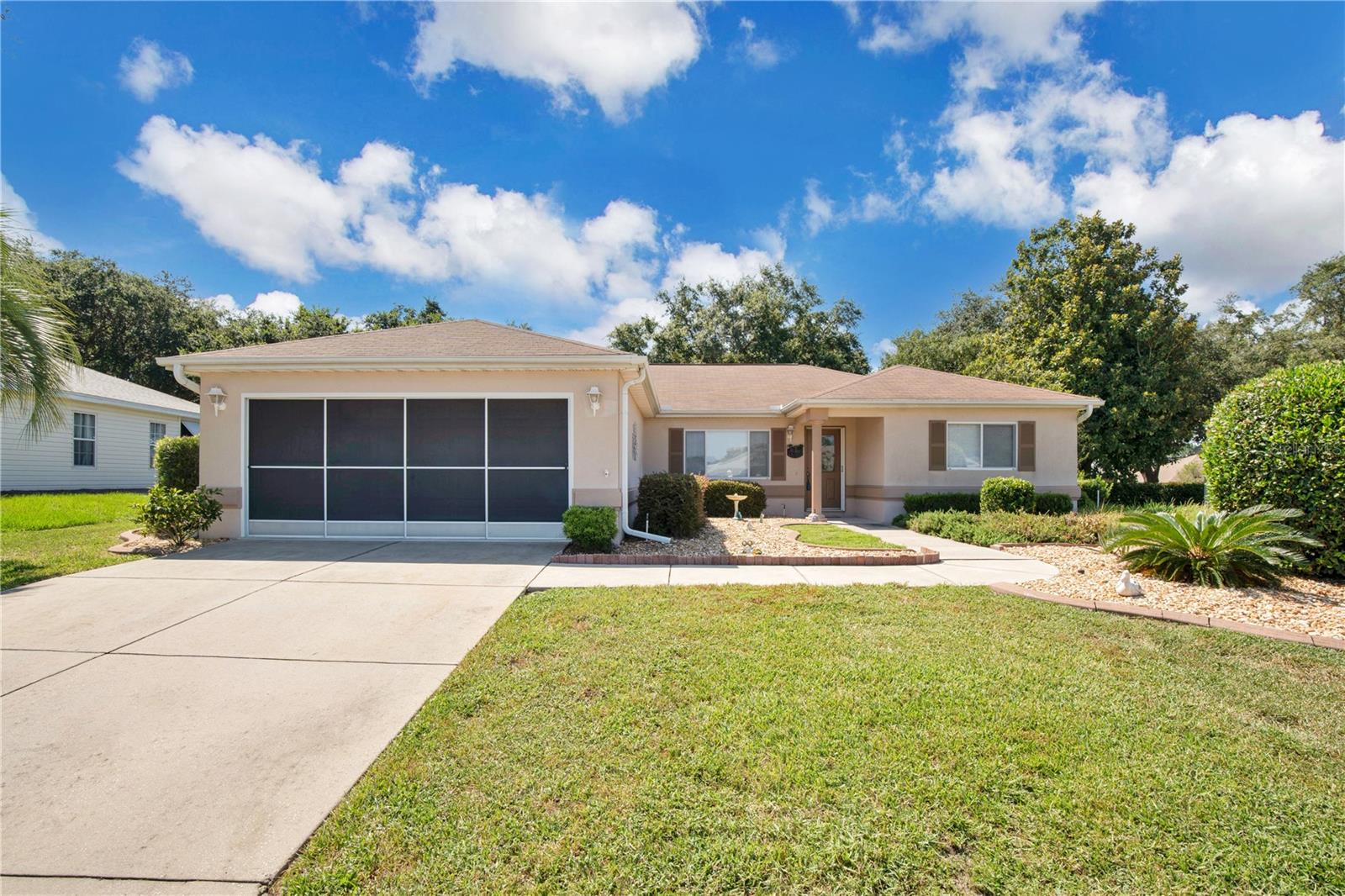 Welcome to the highly sought-after 55+ gated golf community of Del Webb Spruce Creek! This well-maintained 3-bedroom, 2-bath Dogwood model offers a spacious and flexible layout with engineered hardwood flooring in the main living areas and tile in the wet areas. The kitchen features a cozy dining nook and pantry, while crown molding and high baseboards add elegant touches throughout. Enjoy the convenience of a 2-car garage with space for a golf cart and an enclosed laundry room under air. The split-bedroom floorplan provides added privacy, and one bedroom includes built-in bookcases—perfect for a home office. Step outside to a peaceful backyard oasis with mature landscaping, concrete curbing, a glassed-in lanai, and an extended rear patio ideal for relaxing or entertaining. Del Webb Spruce Creek offers outstanding amenities, including a golf course, pro shop, restaurant, clubhouse, fitness center, indoor and outdoor pools, tennis, pickleball, and walking trails. Just a short drive to The Villages with live entertainment, shopping, dining, and medical facilities. Don’t miss your chance to enjoy the best of resort-style living—schedule your private tour today!