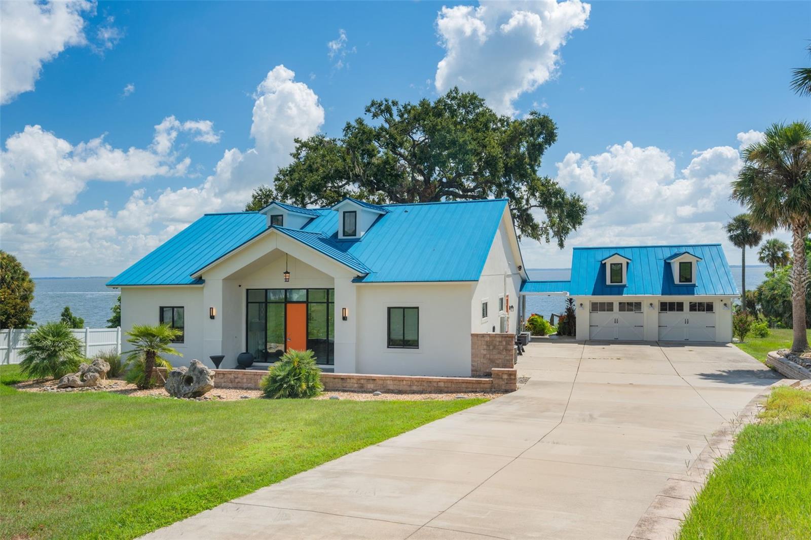 Rare opportunity to own a beautifully updated lakefront home on a private 1.3-acre lot with no HOA in the highly sought-after community of Montverde. This well-maintained 3-bedroom, 2-bathroom property offers stunning water views, modern upgrades, and premium features throughout the home. ideal for a primary residence or peaceful retreat. The home features a spacious open-concept living and dining area, highlighted by large sliding glass doors and expansive windows that flood the interior with natural light and showcase breathtaking lake views from multiple angles. The enclosed sunroom provides a serene space to enjoy your morning coffee while watching the sunrise over the water. The updated kitchen is equipped with granite countertops, a high-end Sub-Zero refrigerator, and ample cabinetry, perfect for cooking and entertaining. The primary suite includes a custom decorative tile accent wall, generous closet space, and a private sliding door with direct lake views and access to the outdoor living space. Additional upgrades include a durable metal roof with professional rain gutters and Leaf Filter protection, a whole-house Generac generator for reliable backup power, and powered solar window shades that enhance energy efficiency and light control. The home also features an Aquasana whole-house water filtration system with housing. The oversized 32' x 24' garage includes new windows and offers plenty of room for vehicles, storage, or workshop use. Two large attic spaces provide even more storage options. Outdoors, enjoy a custom dock built with long-lasting Trex decking and equipped with electric power. Perfect for boating, fishing, or simply relaxing by the water. Located in a peaceful, private setting, this property offers a rare combination of modern convenience, natural beauty, and lake living at its best! Don’t miss your chance to own this unique lakefront gem in Montverde. Schedule your private showing today!