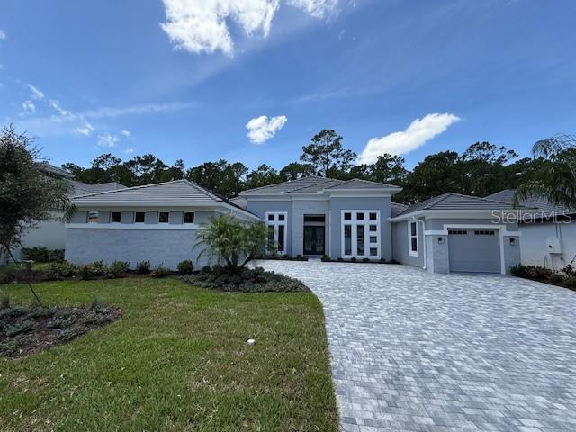 BRAND NEW HOME! Experience luxury living in the award-winning Egret II by ICI Homes—a beautifully crafted, single-story residence offering 3218 square feet of thoughtfully designed space perfect for both everyday living and elegant entertaining. Located in the prestigious Plantation Bay Golf & Country Club, this home features three bedrooms, three full bathrooms, a private study, and a three-car garage, making it ideal for those who appreciate both style and functionality. Step through the grand 12-foot entryway into a welcoming foyer flanked by a formal dining room and a private study with an arched window—setting the tone for the refined design throughout. The heart of the home is an expansive open-concept living area, where the gourmet kitchen, casual dining nook, and living room blend seamlessly under soaring tray ceilings. The chef’s kitchen includes a large center island, generous counter space, pantry, and premium finishes—perfect for hosting or daily living. Just beyond, sliding glass doors open to a spacious covered lanai, ideal for alfresco dining or relaxing in the Florida breeze. The luxurious owner's suite is tucked away at the back of the home for privacy and features tray ceilings, dual walk-in closets, and a spa-inspired bath complete with double vanities, a soaking tub, and a walk-in shower. Two additional bedrooms are located on the opposite wing of the home, each with access to a full bath—an ideal layout for guests or family. Enjoy high-end finishes throughout, a state-of-the-art clubhouse, and an array of top-tier community amenities. Celebrate the holidays in style—your dream home will be ready soon! Exclusive Incentive: Receive a substantial discount on initiation fees for membership of choice to the Plantation Bay Golf & Country Club provided buyers join within 30 days of closing. Peace of Mind Included. Comes with a comprehensive HBW Warranty for added assurance.