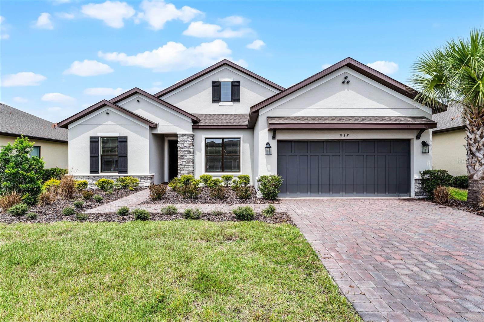 Step into refined living in this beautifully upgraded 3-bedroom, 3-bath home nestled in the award-winning 55+ Solivita community. The inviting paver driveway and upgraded elevation with stone accents create timeless curb appeal. Inside, a formal dining room greets you at the entry, while luxury vinyl plank flooring leads into the heart of the home. The open-concept family room flows seamlessly into the gourmet kitchen, featuring a massive island with upgraded built-in cabinetry, pendant lighting, granite countertops, and crisp white cabinetry. A walk-in pantry and butler’s pantry provide extra storage and prep space, while a built-in drop zone off the garage entry adds convenience. Two private primary suites each include walk-in closets and spa-like en-suite baths with dual vanities, while the third bedroom also features a custom closet system. One suite is enhanced by a striking built-in unit and a custom closet that takes organization to the next level. The family room offers an impressive built-in wall unit designed to fit four TVs, perfect for entertaining. Additional highlights include an oversized laundry room and a two-car garage with pull-down stairs for easy attic storage. Enjoy relaxing year-round on the screened lanai overlooking the fenced yard, or take full advantage of Solivita’s unmatched amenities: multiple pools, golf courses, tennis, pickleball, fitness centers, restaurants, scenic walking trails, and a vibrant calendar of clubs and social events. As an added extra, the golf membership is paid through the end of the year and is transferrable to the new owner. More than a home, this is the lifestyle you’ve been waiting for—set in Solivita, where every day feels like a retreat.