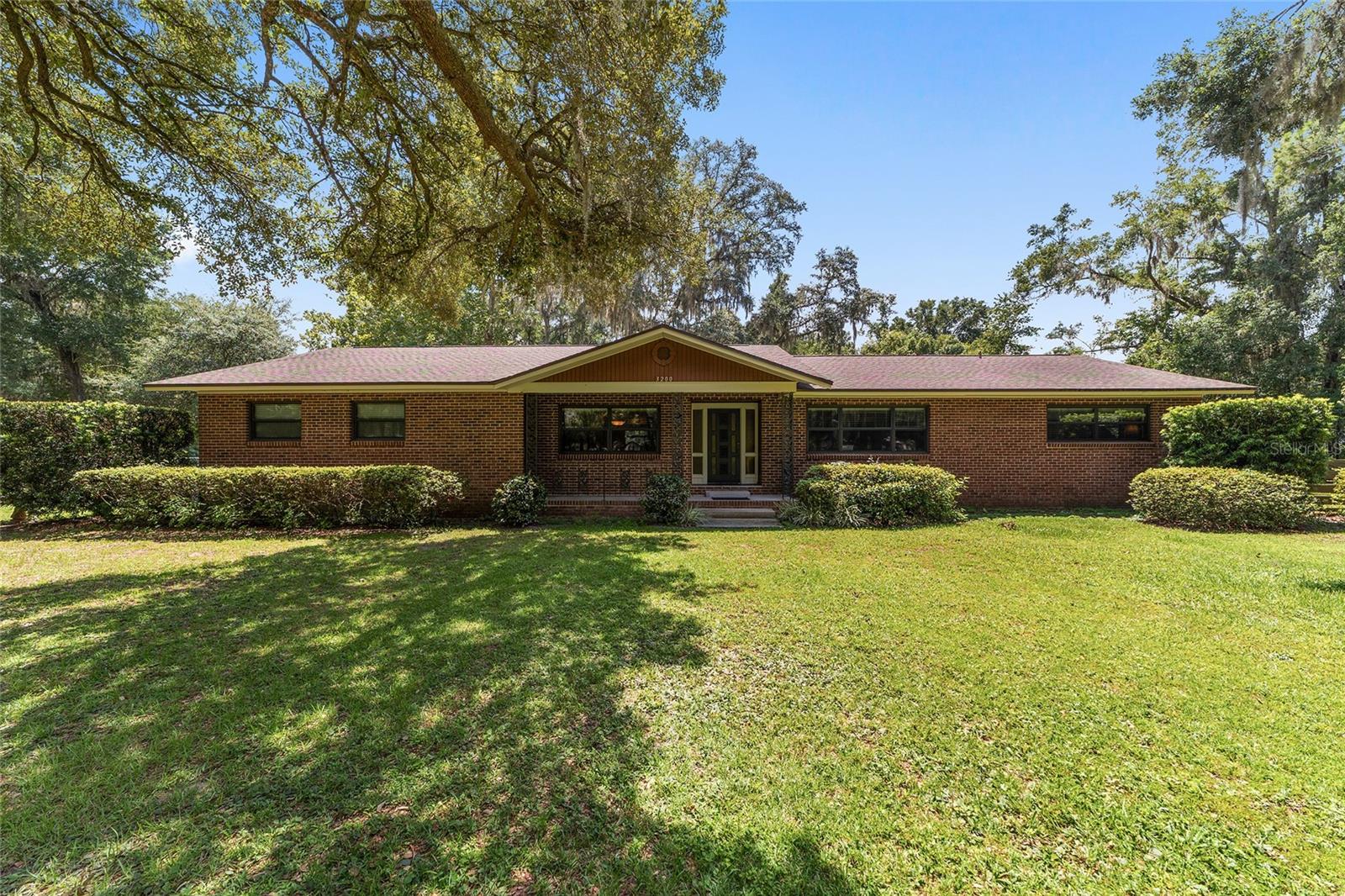If you’re looking for privacy, tranquil country living with a touch of elegance, and room to roam
this stunning 6.85-acre horse-zoned farm is the one for you! Offering 2,358 sq ft of updated
living space, the home features 3 oversized bedrooms, 2.5 baths, and an open, light-filled floor
plan, with large windows throughout. The chef’s kitchen is designed for entertaining with
custom cabinetry, a spacious island, granite countertops, pantry, stainless steel appliances, with a
five-burner gas-top range. The upgraded cabinetry and stone counters carry through to all
bathrooms. Durable porcelain tile flows throughout the home, adding both style and function.
Escape to your serene spacious primary suite that overlooks the private backyard and features a
large walk-in closet, ample space for a sitting area, and a lovely master bath. The two other
roomy bedrooms are separated by a second bright and airy full bathroom. Attention to detail
throughout the interior with custom trim, ceder closet shelving, and solid doors for enhanced
privacy. Step outside to a screened-in back porch that overlooks the most majestic live oak tree
centered in the fully fenced backyard, perfect for pets and private relaxation. Connect with nature
over your morning coffee or early evening refreshment in this tranquil setting with your very
own enchanted forest. A sanctuary with gentle breezes, dusk and dawn light beams shimmering
through the trees and a vast array of birds and other wildlife. The cardinals, owls, hawks,
humming birds, and butterflies await… Additional amenities include a 908 sq ft covered carport
and a 1,380 sq ft detached garage with one bay and an unfinished two-story apartment or office,
offering endless possibilities, including potential income producing. The property also includes a
1.9-acre pasture complete with a versatile cover for horses or livestock. Major updates completed
in 2016 provide peace of mind, with all three buildings reroofed, a 5-ton HVAC installed, and
electrical and plumbing upgrades. A new drain field installed in 2021, a 120-gallon well tank
replaced in 2019, and a 50-gallon hot water heater replaced in 2024. An upgraded water softener
and reverse osmosis system are also included. Conveniently located just minutes from downtown
and shopping, yet perfectly tucked away with plenty of space and privacy, this farm truly offers
the best of both worlds. And for the horse enthusiast, Indian Lake State Forest Equestrian Trails
are located just over four miles away with its 7.8-mile loop-trail for up to three hours of riding
enjoyment. Schedule your private showing today—you won’t be disappointed!