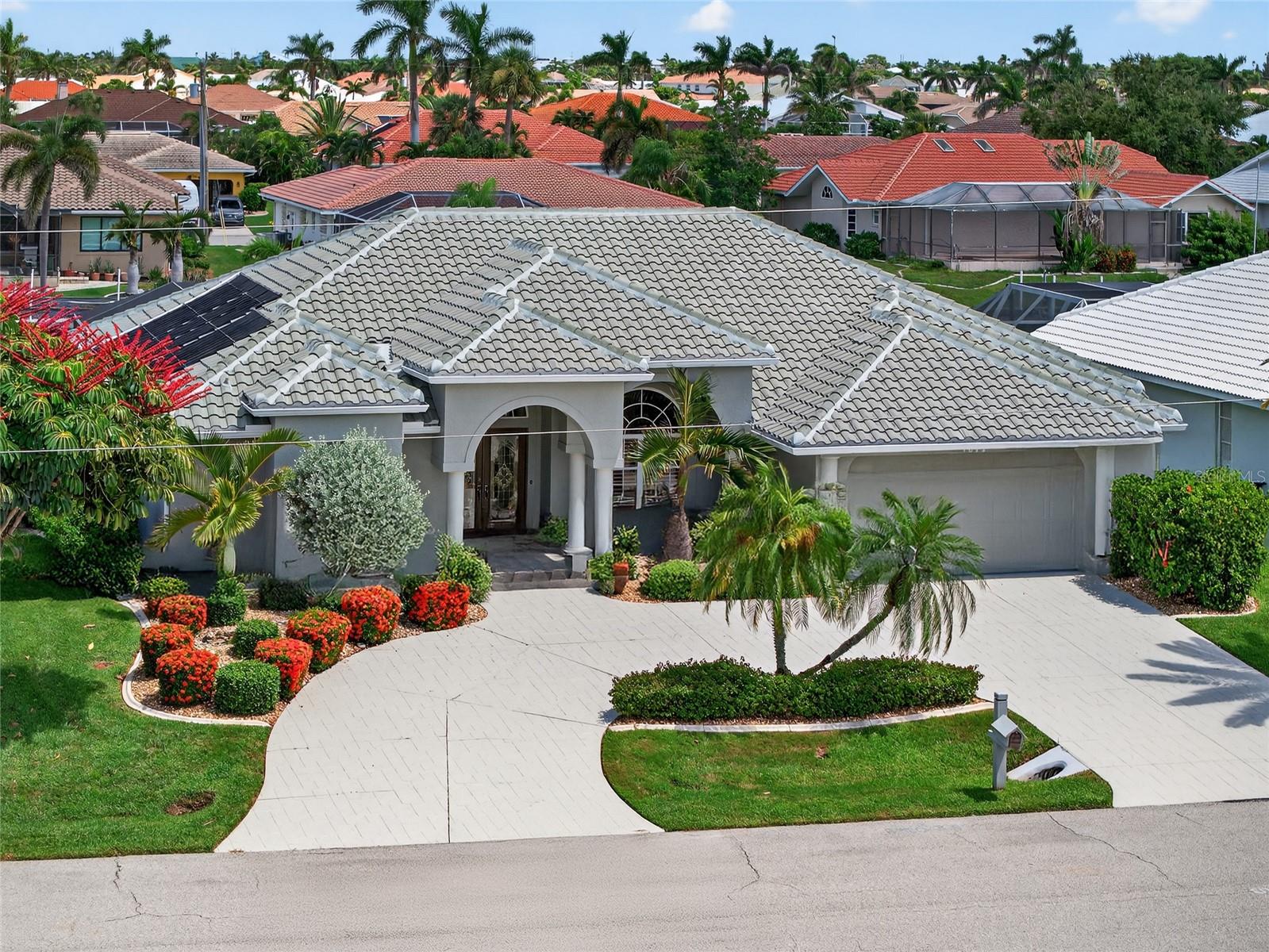 PUNTA GORDA ISLES!! TURNKEY 3 BEDROOM, 3 BATH, 2 CAR GARAGE, WATERFRONT POOL HOME WITH POWERBOAT ACCESS MINUTES TO CHARLOTTE HARBOR LEADING TO THE GULF! 76 FT OF WATER FRONTAGE, 30 FT CONCRETE DOCK WITH WATER AND ELECTRIC PLUS 10,000 LB. LIFT. Stunning curb appeal with mature and lush exterior landscaping. Step inside through double door entry to open, split floor plan with beautiful water views, high ceilings, crown molding, plantation shutters and tile/wood floors throughout. Gourmet kitchen offers ample cabinetry for storage, tile backsplash, stainless steel appliances, aquarium window overlooking the lanai and pool, and breakfast bar great for entertaining. Generous primary suite features access to lanai, his and her walk-in closets with custom shelving and private en-suite bath featuring dual sinks, soaker tub, and walk-in shower. Split floor plan provides guests with plenty of privacy with 2 additional bedrooms with walk-in closets and 2 full guest baths. Additional features include inside laundry room, central vacuum, workshop area in garage, new roof 2024, new pool cage 2023, pool bath, irrigation system, 200 gallon buried propane tank in front yard and circular driveway. Outside enjoy the screened lanai with propane and solar heated pool, outdoor shower, and breathtaking water views. Located on a quiet cul-de-sac street with deed restrictions and no HOA in a popular golf and boating community close to St. Andrews South Golf Club, the Yacht Club, Fishermen's Village, and the historic downtown area of Punta Gorda. Enjoy access to arts, community events, entertainment, world-class fishing, boating, fine dining, and beautiful parks, as well as easy access to the SWFL gulf beaches. Don't miss your chance to own this waterside treasure! Schedule your private showing today!