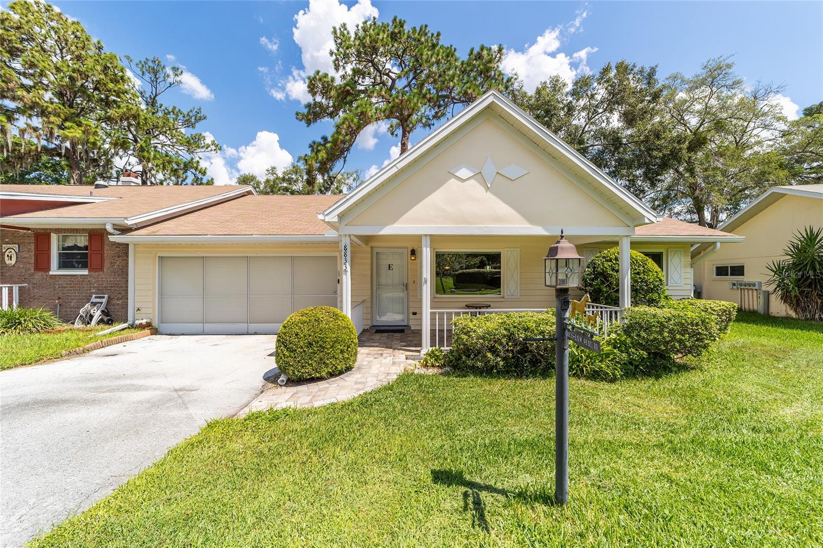 One or more photo(s) has been virtually staged. PRIVACY END UNIT: Welcome to this beautifully updated Expanded Montgomery Villa, featuring 2 spacious bedrooms, 2 bathrooms, and a coveted 2-car garage. The home has seen several upgrades, including new windows and a new water heater in 2017, as well as an upgraded HVAC system in 2018. The updated kitchen boasts oak cabinets and sleek quartz countertops, ideal for cooking and entertaining. Throughout, you'll find recessed lighting and laminate floors, providing a contemporary feel to the open, airy space. The villa’s curb appeal is striking with a new front door with glass insert for added light, a brick paver porch and walkway, and a lush, well-maintained lawn. In addition to being an END UNIT, this villa enjoys added privacy with no rear neighbors. The main bedroom is generously sized with a large walk-in closet and an elegantly updated shower. This home has the added benefit of an enclosed 4-seasons lanai, offering versatility as an office, craft room, or cozy Florida room—all under heat and air for year-round comfort. On Top of the World is Ocala's premier 55+ active adult community with an abundance of activities and golf cart access to restaurants, shopping, entertainment, health and beauty.