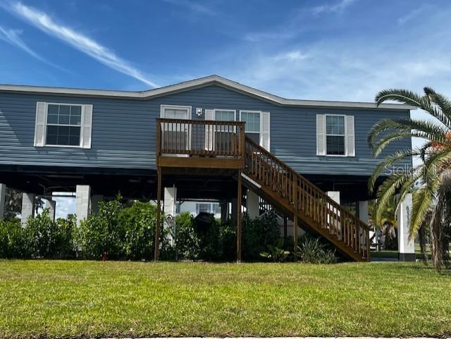 MUST SEE!!! This Open Concept Split Floor Plan 3 Bedroom 2 Bath 2023 Stilt Built Doublewide Manufactured Home with a 15' Elevation has A new 8x26 Upper Deck overlooking a view of the Gulf of Mexico. Front Deck and stairs to the front door. New concrete driveway with covered parking under the home for several cars or plenty of room for a storage shed, picnic tables and entertaining. Or in the future use your imagination of how you could utilize all that extra space! (For a game room, extra family space, a man cave, or office with county permitting) Rear yard is spacious for family gatherings and Bar BQ'S. Fencing allowed with county permitting. Exterior features a New Seawall with a deep-water canal; an 8x12 Floating Dock. The lot itself is a lot and a half. Wow very spacious for waterfront living! Block and concrete columns and an end of canal corner lot with no boat traffic. Wake up to the sound of nature and go to sleep peaceful by the water. Straps for the home are welded every 4 feet and attach and strapped over entire home itself. (see plans) The Home features a Great Room with vaulted ceilings and crown molding opening up to beautiful kitchen cabinets, stainless steel appliances, a spacious center island breakfast bar with more cabinet storage, farm sink, pantry, walk in closets, and so much more. This home is finished in a blue vinyl siding and a light color shingle. Very Beachy!! Interior Island beadboard and dining beadboard is also light in color. Windows have blinds and toppers already in place for privacy. Already to move right in! Community has a clubhouse with activities and private boat launch ramp for a minimal joining fee. This will be the ultimate in waterfront living without breaking the bank. Nearby sandbar fun just minutes away by boat. Close to famous beaches, restaurants, shopping, hospitals and Tampa International Airport.