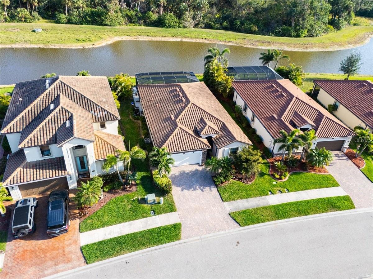 Welcome to your spectacular 4-bedroom, 3-bathroom home with more than 2,000 sq.ft. of living area, built in 2017, featuring a sparkling private SWIMMING POOL and a WATERFRONT PRESERVE VIEW! All this is situated within the desirable gated community of Gran Paradiso! Embrace the Florida lifestyle in the TREVI model, renowned for its open floor plan and thoughtful design. This particular model boasts numerous upgrades, with closets that have custom built-in shelving, GRANITE COUTERTOPS everywhere, custom designed wall cornice in the foyer/hallways, and the predominantly tiled floors throughout are both elegant and also easy to maintain! Your kitchen includes STAINLESS STEEL APPLIANCES, a WALK-IN PANTRY with custom built-in shelving, a granite countertop with a tile backsplash, AND an upgraded/extended kitchen island with QUARTZ COUNTERTOP along with a classy tile backsplash beneath the bar! Your primary suite includes a well appointed en-suite bathroom with a garden tub and glass enclosed shower! Your remaining 3 generously sized guest bedrooms and 2 guest bathrooms ensure privacy and comfort for you and any guests. Entertaining out-of-town visitors will be a delight, as the layout provides ample space and seclusion for extended stays. Living in paradise means friends and family will be eager to visit! Heading through the sliding glass doors you can relax and/or entertain with the heated two-year-old swimming pool which includes therapy jets, custom lighting, and a structurally reinforced cage with PANORAMIC screened enclosure for unobstructed views of the POND and PRESERVE! Step outside to the extended lanai with TRAVERTINE PAVERS imported from Italy and take in the wide-open view of the water and preserve beyond! The water view and preserve setting make for a highly sought-after living experience that is tranquil peaceful and beautiful! Your home has been meticulously maintained and just had a new water heater installed in 2024. Your garage has an attic vent fan installed for efficiency, an insulated garage door, and the garage floors have been epoxied. Putting up shutters is a breeze with your ACCORDION HURRICANE SHUTTERS and the electrical panel has been upgraded with surge protection! The gated entrance, staffed by friendly guards, ensures security along with a warm welcome every time you come home. Gran Paradiso is part of the Wellen Park planned master community, a vibrant hub of Sarasota County. Here, you'll find an array of activities to keep you engaged, including the Atlanta Braves ballpark for exciting spring training games, fireworks displays, dining options, tree lighting events, shopping, water activities, biking trails, and a splash park for the little ones. Within your own community, enjoy the resort-style amenities Gran Paradiso has to offer, including a resort pool, a state-of-the-art fitness center, sauna, basketball courts, tennis courts, pickleball courts, and a grand clubhouse! Stay informed with the monthly newsletter detailing all of the things to do and happenings in the community. Come and relax worry free—you are going to love it here in Gran Paradiso. This inviting home offers the perfect blend of comfort, luxury, and community. Don't miss the opportunity to make it yours!