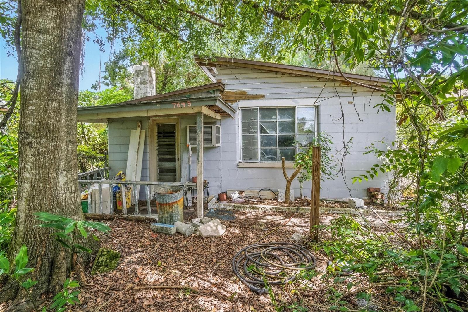 Opportunity knocks in the heart of Pinellas Park! This 1-bedroom, 1.5-bath concrete block home has been in the same family for nearly 30 years and is ready for its next chapter. The property sits high and dry in a non-flood zone, but did still sustain some damage when a tree fell on the home during last year’s hurricanes. This is an ideal project for investors, builders, or buyers with vision. Set on an almost 1/4 acre lot with approximately 200 feet of depth, the possibilities are endless—renovate and restore the existing home, expand with additions, or clear the site to build your dream home from the ground up. A detached concrete block garage with drive-through doors adds additional value and functionality, providing ample storage or workshop space with easy backyard access. Just steps away, Davis Field is about to undergo a $23.5 million transformation into a premier youth sports complex featuring upgraded athletic facilities, community spaces, and park amenities. This exciting city-backed project will bring new energy, activity, and value to the surrounding neighborhood—making this property’s location even more appealing for the future. Centrally positioned in Pinellas County, you’ll enjoy quick access to schools, shopping, dining, major interstates, award-winning Gulf beaches, and vibrant Downtown St. Petersburg. Mature trees and lush vegetation provide shade and privacy, adding to the charm of this spacious property. Bring your creativity and take advantage of this rare chance to own a large lot with so much potential in a convenient, growing area of Pinellas Park. Schedule your showing today!