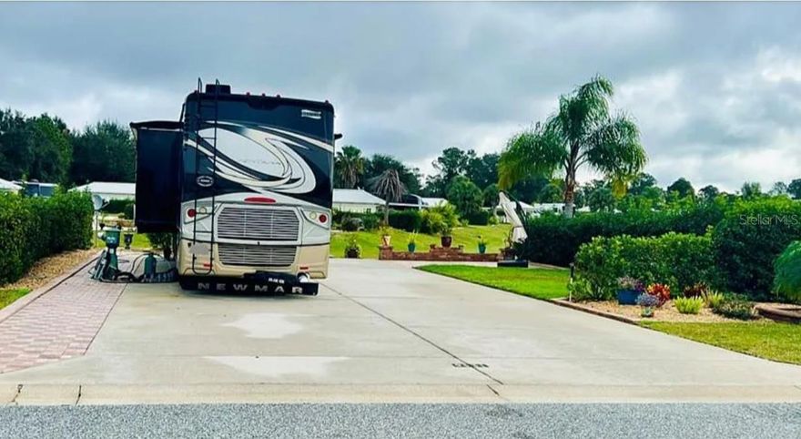 Welcome to your Florida Grande Motor Coach Resort oasis! Lot 280 beckons with its east-facing charm, promising breathtaking sunrise views that paint the sky with hues of warmth. Sprawling over 5000 sq ft, this pull-in property boasts meticulous hardscaping, including a paved pedestal side adorned with elegant pavers. Step onto the 14’x16' patio, a haven of outdoor living crafted with precision. A decorative wall frames the picturesque water view, creating a cozy retreat for relaxation. Lush foliage strategically planted enhances both ambiance and privacy, making this lot a serene escape. There is room to build a 384 sq ft Grande Suite on the property if you choose or leave it just as it is. On the street side, discover more hardscaping and landscaping, infusing the property with a warm and inviting atmosphere. Florida Grande, an all-ages, gated Class A and Super C resort, awaits in the heart of Central Florida.  Just an hour away from Tampa, Orlando, and Ocala, and a mere 30 minutes from The Villages, convenience meets luxury. HOA fees of $995 per quarter covers water, sewer, trash, mowing, and irrigation services are included, along with access to an array of resort amenities. Engage in activities at the dog park, 8 new pickleball courts, pool, hot tub, or the 20,000 sq ft clubhouse, a hub of social connectivity. With a “Grande Room” hosting various activities and special events, a fitness center, library, billiards room, craft room, and more, the clubhouse is a testament to the vibrant community spirit. Bring your furry friends-two pets are welcome per property. Florida Grande isn’t just a resort, it’s a community that pulsates with life. Schedule your appointment to explore Lot 280 or extend your stay to immerse yourself in the unparalleled lifestyle this resort has to offer. Your dream motor coach lifestyle awaits!