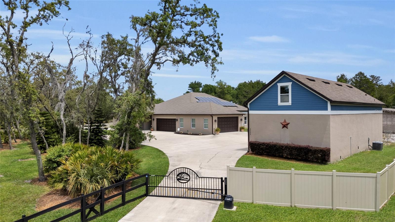An EXCITING NEW PRICE has just been set for this exceptional property as it was recently appraised! Your Private Oasis Awaits in Mount Dora! Step through the electronic gate of this exceptional 2017-built estate, nestled on over 2 acres of fully fenced land, and discover a lifestyle of modern comfort and incredible versatility. From the moment you enter, a stunning view of the heated saltwater pool and spa draws you in. The heart of the home is a spacious, warm family room conveniently located off the kitchen, perfect for gatherings. Culinary enthusiasts will adore the kitchen, showcasing top-of-the-line stainless steel appliances, granite counters, an oversized island with barstool seating, and a large walk-in pantry. This thoughtfully designed home offers generous, oversized spaces including 4 bedrooms and 3.5 baths, plus a dedicated multi-use wing ideal for crafting, workout area, an office, or a den. The multi wing of the home could easily be converted to 3 bedrooms by simply adding doors and closets to make this home potentially 6 bedrooms. The primary suite is a true retreat with stylish farm doors leading to the en-suite and a remarkable designer closet featuring built-in shelving, accessible from both the bathroom and the laundry room. Beyond the luxurious interiors, a substantial 1320 sq ft detached workshop / accessory building with a loft bedroom and full bathroom (with its own separate septic system) provides endless possibilities and has AC as well. Have a car collection? The bottom floor is perfect and has room for 4 vehicles! Even more features on the property include covered RV and boat parking with a 50 AMP electric area and eight pole barns. In addition there is a Generac system that has 2, 250 Gallon propane tanks. Adding exceptional value, the solar panels are paid off! Indulge in a life of ease and sophistication, with Mount Dora's vibrant cultural scene, charming shops, excellent schools, and top-rated hospitals all within easy reach.