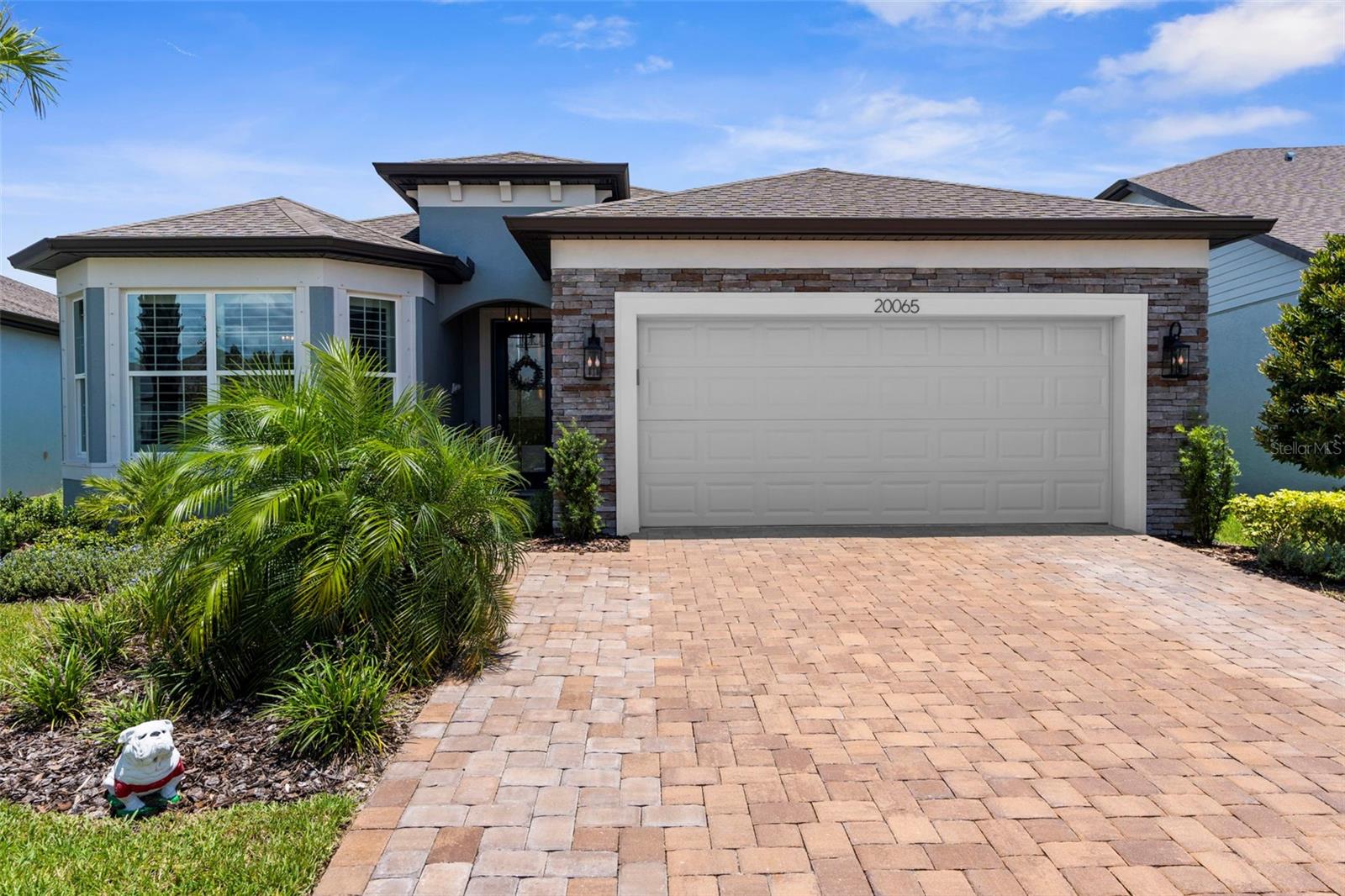 Popular Mystique model, located in the gated 55+ community of Del Webb Bexley, 1916 sq ft of meticulously maintained and upgraded living space with 2-Bedrooms, 2-Bathrooms, ADDITIONAL FLEX/DEN SPACE/ROOM with French doors (Currently being used as a 3rd bedroom), Oversized 2-car garage with a 10x15 tandem space area for extra storage or your golf cart (extra outlets in garage), coated garage floor. Manicured lawn and landscaping (maintained by the HOA), brick paver driveway(widened), stacked stone-accent front exterior, and decorative glass front door. Luxury vinyl plank flooring runs throughout the home, with tile used in the bathrooms and laundry room. Custom neutral interior paint and plantation shutters (Over 10k installation for the shutters). The Chef’s kitchen with quartz countertops, upgraded 42-inch cabinetry and hood range with pull-out shelving and soft closing, under-cabinet lighting, beautiful backsplash, walk-in pantry built out, an extended island with breakfast bar, stunning pendant lighting (with dimmer switch), 5-burner gas cooktop, Kitchen Aid stainless appliances. The refrigerator is included but was not part of the KitchenAid package. The kitchen is adjacent to the dining area (with chandelier on dimmer) and open to the living room, which is adorned with a tray ceiling and crown molding. The room features a built-in surround sound system with a premium receiver and subwoofer, controlled by a remote and conveys. The living room and dining room have sliders to the brick paver Lanai overlooking the backyard, with a fence on the back of the property. The lanai gas line installed for your grill hookup or future outdoor kitchen and wired for an outdoor TV. The primary bedroom is located off the dining room, towards the back of the home, to ensure privacy. It includes a luxurious en-suite with dual sinks, two custom-framed mirrors, quartz countertops, a spacious custom-tiled walk-in shower with a built-in bench, a linen closet, and a walk-in closet. The laundry room has custom cabinets with a laundry sink, quartz countertops, and upgraded handles. The front bedroom features a built-out bay window area that allows for a sitting space (extended bedroom space). The second bathroom is located right outside the front bedroom, featuring a tile shower/tub combo, a quartz countertop, and a tastefully selected mirror. Tankless water heater, Water softener, Synergy Security System, which includes Ring Doorbell, garage door, and an app to control HVAC. Not to mention the custom board and batten accent wall in the entry hall and living room. The high-end custom lighting, cabinet pulls, and lovingly selected mirrors throughout are just a few of the attention-to-detail upgrades. Del Webb offers the Fabulous Florida Lifestyle with active social community and amenities center including Resort-Style Pool, Resistance Pool, Hot Tub, and Cabanas, Expansive 19,000 sq. ft. Clubhouse, Fitness Center, Cafe/Bistro, Pickle Ball & Tennis Courts, Dog Park, and Social Clubs/Groups. Close proximity to shopping, restaurants, entertainment, medical facilities, FL-54 & FL-589(Suncoast). Easy commute to Downtown Tampa and Tampa International Airport. This home will not disappoint!! Check out video walkthrough and call to schedule a private showing today!!