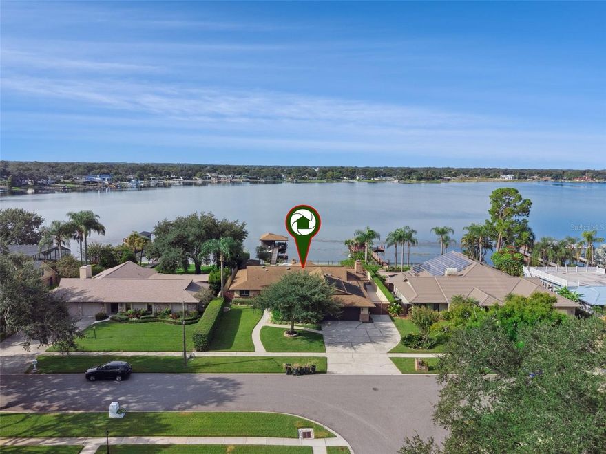 Your Lakeside Sanctuary: Experience this meticulously maintained home, where every detail is designed for comfort and convenience. You will be captivated by the vivid, colorful sunset views over the water, the perfect backdrop for relaxation and entertaining. The custom-built dock (2020) is a highlight for any boating enthusiast, offering effortless access to the water. Features include: Electric Boat Lift: Complete with a pontoon cradle and a newly installed (2023) electric boat cover for protection. Amenities: A covered seating area with a ceiling fan, an open fishing spot, a lighted dock walk for safe night-time use, and practical conveniences like electric outlets, a water hose, and an outdoor shower for easy clean-up. The Backyard A fenced backyard, transforming it into an all-in-one entertainment complex: Custom Pool: Dive into the large (475 sq. ft.) pool, installed in 2018, featuring solar heating panels (2019), colored LED lights, and decorative water bowls. A dedicated pool half-bath and exterior shower complete the resort-style experience. The Summer Kitchen: Host unforgettable gatherings in the covered 24’x25’ summer kitchen (2017). This entertainer’s dream is fully equipped with a stainless-steel Coyote grill, side burner, beverage refrigerator, sink, countertops, cabinets, dining area, separate seating lounge, and four ceiling fans. Gardener's Delight: Open and screened-in garden area, perfect for growing vegetables, alongside a pergola draped in grapevines. Unwind at the brick fire pit under the stars Dedicated Space for Hobbies, Tools, and Toys. This property includes versatile storage and utility areas to accommodate every need: The Auxiliary Building: A versatile 10'x20' auxiliary building (2017) with a concrete floor and ample electricity. It’s ideal for storage, or easily convertible to a studio, home office, or gym. RV & Boat Storage Pad: A 39'x11' concrete pad provides worry-free storage for your RV or boat. Oversized Garage: The 800 sq. ft. garage fits two vehicles and includes a workshop area with storage cabinets, pegboard walls, and a slop sink. It also houses the central vacuum system and a 50-gallon Hybrid water heater. Modern Comfort & Efficiency The interior is equally impressive, blending modern elegance with functional design: Gourmet Kitchen: A chef’s dream, featuring GE Café appliances (2021), abundant cabinets, and ample counter space. Spacious Family Room: The kitchen flows seamlessly into the large family room, which features custom cabinetry, a brick accent wall, and a cozy 48" wood-burning fireplace. Bedrooms & Bathrooms: Four spacious bedrooms, including a large master suite with a walk-in closet and a bay window overlooking the lake. The home offers three full bathrooms, including a walk-in shower in the master and a Jacuzzi tub in a guest bath. Cohesive Design: Porcelain tile flooring runs throughout the entire house for a modern cohesive look. Key Home Features & Energy Upgrades This home is built for long-term comfort and efficiency, ensuring lower utility costs New Roof (2018), Photovoltaic Solar Panels (2019) for dramatically lower electric bills. Insulation: 18 inches of blown-in attic insulation (2024) with two attic fans. Energy-Efficient Windows: High-efficiency Thermopane windows and exterior French doors throughout with low-E coating. Security: An already installed ADT security system for your peace of mind. Ready to see your new lake house?