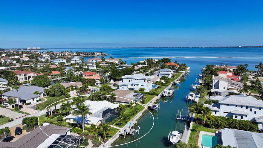Plan to be “wowed” by this meticulously redesigned home in Country Club Shores, one of Longboat Key’s most coveted neighborhoods. A reimagined "jewel," this home’s incredible makeover evokes the aura of a designer model home. Situated on a wide canal with views of Sarasota Bay, this property has had nearly everything replaced, rebuilt, and re-designed to enhance its waterfront location. This “Perfection in Paradise” has been impeccably maintained and improved, making it an entertainer’s delight, and a boating enthusiast’s dream. A welcoming foyer with double doors with occluded glass embraces the relaxing living room for entertainment with access to terraces and the pool. The open split floorplan offers a gorgeous chef’s kitchen that boasts the large island as the focal point with fantastic storage, a Jenn-Air induction cooktop, convection oven/microwave and warming drawer, Sub Zero custom built-in refrigerator and freezer, built-in wine captain with backlit custom cabinetry and state-of-the-art Wolf steam oven. The marble and stack stone mosaic backsplash adorns the custom granite countertops creating a warm and inviting space. A pass-through window makes serving guests a breeze. The elegant dining room with a custom chandelier has two open walls to include all the activity centering around the opulent, grand kitchen. The primary suite is a relaxing retreat with a chic en-suite bath features quartz and tile surfaces, a large walk-in shower, dual vanities and a walk-in closet with smart storage. Custom French doors separate the owner's retreat from a versatile flex space, currently used as a library, that has many options for the imaginative buyer. This charming, magical space is adorned by a wall of windows that open to a sensory wonderland of jasmine and gardenia aromas and a serene water feature that melts away stress. The additional en-suite offers the potential for extended stays with private access, captivating water views, and a custom walk-in closet. The adjacent guest room, currently being used as an office/den, features a large walk-in closet with attic access, amazing light, and space, and can easily fit two twin beds. A separate full bath and mirrored linen closets ensure comfort and convenience. Outside, your backyard oasis awaits! Enjoy the expansive newly screened patio with sparkling saltwater pool with new Pebble-Tec finish, and an illuminated water feature. The new state-of-the-art built-in outdoor kitchen features a Stainless-Steel cooktop/burner, grill, and refrigerator with ample seating space for entertaining guests all year-round. The entire patio is protected from the elements with sliding hurricane shutters, for peace of mind. For boating adventures on the water, the new Trek dock features a boat lift, with electrical and water hookups. Surrounding this beautiful home is lush landscaping, numerous mature palms, and flowering bushes with a paver walkway that wraps around the entire property. The 2+ garage includes shelving, access to attic storage and two hurricane-rated garage doors. This amazing residence with deeded beach access, exceptional upgrades and high-quality finishes will astound you. Located within minutes to St Armands Circle to enjoy shopping and numerous casual and fine dining restaurants and just a quick drive to Downtown Sarasota where you will find a vibrant art scene and active downtown vibe. Don’t pass up this opportunity to live your best lifestyle here on Longboat Key.