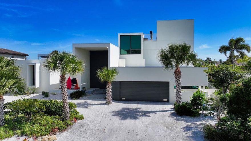 Introducing a masterpiece of modern design. This custom European-style home, located in the highly sought-after community of Country Club Shores on Longboat Key, offers a unique blend of luxury and harmonious living. With a private beach access and minutes from St. Armands Circle, this property offers a prime location and a sophisticated, tranquil lifestyle. Designed by the renowned architect Michael Halflants of Halflants & Pichette, this European modern home is a true work of art. Every detail, from the bathrooms with zero-transition showers to the Japanese style “genkan” entryway, reflects meticulous attention to modern design. The interior features porcelain tile throughout, custom metalwork, a generous second-level mezzanine serving as a cozy reading nook or yoga studio, and a rooftop entertainment area with a wet bar, large custom parasol, a substantial seating area, and stunning panoramic 360° views across Sarasota Bay and city lights. Embrace this open-plan’s great room with walls of windows that complement the sleek quartz island kitchen with European cabinetry, induction cook-top, and all the modern conveniences to entertain your guests in style! The fully pocketing sliders in the great room are designed to incorporate the outdoor patio with the help of a motorized custom awning that essentially forms an expanded covered indoor/outdoor living space with the touch of a button - enjoy the lush outside space and picturesque water views with complete privacy and protection from the elements. This custom designed 4-bedroom plan features 2 separate guest bathrooms, one with a walk-in shower and the other with jetted tub and shower, integrated Toto washlet, with Grohe fixtures to further distinguish the European finesse. Enter the luxurious owner’s retreat via a 10’ pivoting door and enjoy the Zen-like feeling as you gaze out at the canal or tip-toe down your private entry to enjoy a midnight swim. The sexy bright and stylish bathroom has a generous walk-in shower, dual bowl-sink vanities, a deep soaking tub, and a wall of windows which integrates a private orchid “pocket garden” into the space, enhancing the spa-like experience. Additionally, your personal belongings are professionally managed with a high-end custom closet system. Outside, you'll discover 100 feet of waterfront serenity, complete with a seawall, dock, and 10,000-Lb boat lift. The surrounding landscaping features primarily Florida native vegetation, incorporates multiple seating areas, and has an original custom sculpture by N. Rabins. Recent updates include new AC units (October 2023, 10-year warranty), EV car charger, and a climate-controlled garage workshop with bike storage and garden windows to bring in ambient light and to enjoy your blooming flowers. Experience the pinnacle of modern living in this exceptional home, where everyday living is elevated into a serene art form, surrounded by breathtaking beauty and impeccable design. Enjoy your deeded private beach access just minutes away or enjoy fishing on your own dock. This location is ideal, adjacent to the Resort of Longboat Key Club (membership required), and easy access to shopping/dining in St. Armand’s Circle and downtown Sarasota. Don’t miss this opportunity to live the island lifestyle in paradise.  The home is being offered lightly “turnkey” furnished (exclusion list provided).