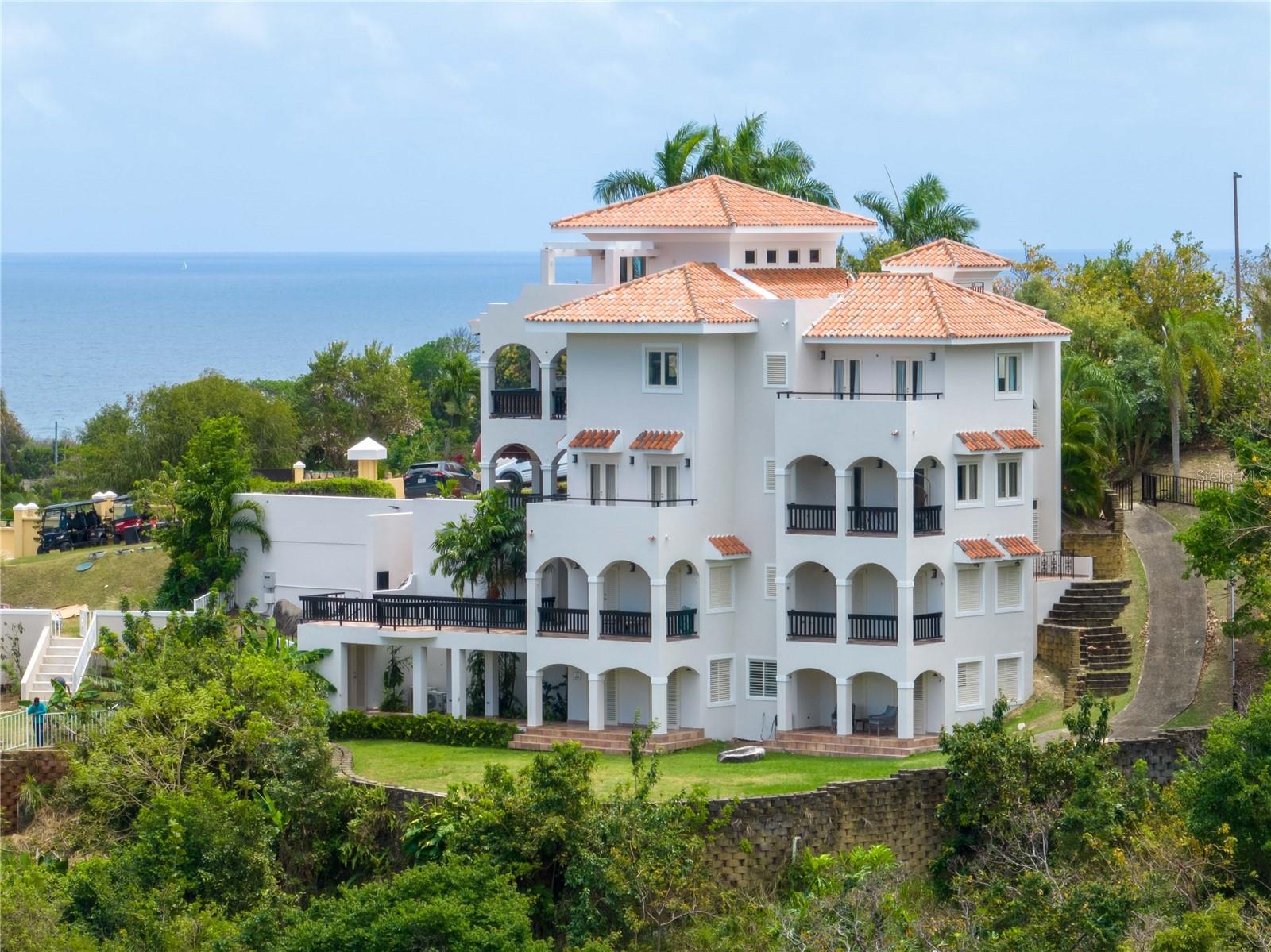 Welcome to a one-of-a-kind home in the heart of Palmas del Mar! This stunning 4-story home boasts exceptional features that make it a standout investment. Each floor is designed as a self-contained unit with its own kitchen and laundry room, perfect for multifamily living or rental income potential.
Starting from the bottom, the first floor offers a spacious one-bedroom apartment with a comfortable living room with a sofa bed, a fully equipped kitchen, a separate dining area, a private bathroom, a generously sized bedroom, and a convenient laundry room. Moreover, this floor provides direct access to the backyard, offering endless possibilities, such as adding a refreshing pool or creating an outdoor oasis for relaxation and entertainment. The mountain view from this floor are impressive!
Ascending to the second floor, you'll discover a charming 2-bedroom, 2-bathroom apartment featuring a well-appointed kitchenette, a dedicated laundry room for added convenience, a private terrace ideal for enjoying the Caribbean breeze, and a large balcony that showcases breathtaking mountain views, making every moment spent outdoors a true delight. From this floor up, the units are connected and accessible with an elevator.
The third floor continues to impress with another thoughtfully designed living space, including a cozy living room, a spacious kitchen with ample storage and counter space, two comfortable bedrooms, and a Jack-and-Jill bathroom, plus a half bathroom. This floor also boasts a private balcony, providing a perfect spot to unwind and soak in the panoramic vistas surrounding you. From this level up, you can enjoy the extraordinary mountain, ocean, and marina views.
Finally, the fourth-floor crowns this magnificent home with a stunning terrace, offering unparalleled views of Palmas del Mar and beyond. This expansive outdoor area is ideal for hosting gatherings, enjoying sunsets, or simply basking in the tropical ambiance that defines Puerto Rico living. The master bedroom is located on this floor with its ensuite bathroom plus a half bathroom for guests, as well as the living room, dining room, and kitchen with an open layout concept, as well as a loft that is currently used as a home gym, but could also be an office.
Additionally, this property features convenient amenities such as dedicated parking, easy access to nearby attractions, and the vibrant Palmas del Mar community amenities, including golf courses, tennis courts, beach access, dining options, and more.
Don't miss this rare opportunity to own a versatile and income-generating property in Palmas del Mar. Schedule your private tour today and experience the luxury and potential this home has to offer!
Palmas HOA: $1,042/year
CRIM (Property taxes): $4,546/year ($3,221/year w/exemption)