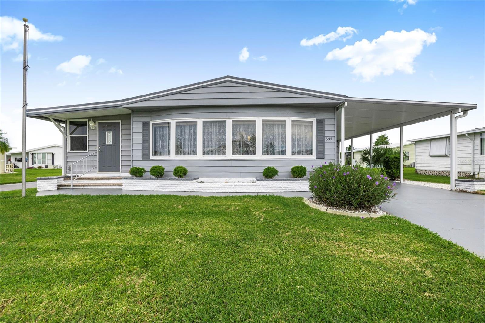 Charming two-bedroom, two-bathroom home situated on a spacious corner lot. The home features a newer side entry door. The kitchen boasts a tiled floor, ample cabinet and drawer space, a pantry, a disposal, a newer stove, and a dishwasher. There is a dining room adjacent to the kitchen, complete with a built-in hutch. The open concept layout connects the dining and living rooms. The living room is enhanced by new front windows and includes a pocket sliding door leading to a carpeted, insulated, heated, and cooled Florida room, which also has newer windows and a new front door. The guest bedroom features a walk-in closet and a built-in chest, providing access to the guest bathroom, which includes a linen closet, a tiled tub/shower, and a newer vanity. The primary bedroom offers two double closets and newer furniture, including an adjustable bed. The primary dressing area has a his-and-hers vanity with center drawers for extra storage. The primary bathroom includes a tiled walk-in shower, a linen closet, a storage chest, and a ceramic tile floor. Pergo flooring is installed over plywood in all rooms except the guest bedroom. Additional features include a standing seam metal roof, a new carport, and a vapor barrier. The Trane A/C unit is approximately 8 years old. The property also has an automatic sprinkler system and was repainted on the exterior in March 2024 and new vapor barrier in 2025. Access to the utility room from the long carport includes a deep sink, washer/dryer, workbench, tools, and storage. There is also a rear utility room housing a water heater and additional storage for gardening equipment.
La Casa offers the ultimate lifestyle on Florida’s Gulf Coast is located between Sarasota and Fort Myers and is a boaters dream with access to the Gulf of Mexico. It is convenient for shopping, sightseeing, golfing, fishing, and boating, as well as all the culture and elegance the Southwest Florida area is noted for. Residents and visitors enjoy the warmth of Southwest Florida winters in a relaxed and unhurried environment far removed from the hustle of Florida’s east coast. You’ll be surrounded by hundreds of palms reaching for the sky and beautiful mature lush landscaping which demonstrates the utmost level of care our property receives from residents and management. La Casa may have the best pools in the area. Our extremely large, 40 X 60-foot swimming pool is our crown jewel and that is kept at a perfect 87 degrees. Our smaller 20 x 40 pool is quietly nestled between the clubhouse and the Activity Building. Both pools have adjacent hot tubs which are ideal for soaking muscles that are tired from golfing or tennis. Wireless Internet (Wi-Fi) is available at the Clubhouse, Activity Building, and Recreation Hall area where these pools & spas are located, so you can catch some rays while you catch up on your email! Sound enticing? La Casa is a friendly, family community. You will be away from the hustle and bustle except when you want to be part of it. When you leave our gates, North Port is only 1.5 miles from the city center, where you will find every kind of retail store and service you could need. Come for a visit to this self-contained oasis and see for yourself why La Casa is the ultimate destination for both snowbirds and year-round.
