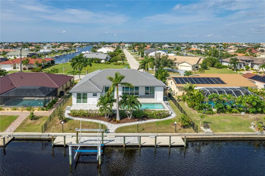 One or more photo(s) has been virtually staged. PUNTA GORDA ISLES!  BEAUTIFUL 2018 BUILT 3 BEDROOMS, 2.5 BATH  3 CAR GARAGE HOME WITH HEATED POOL. OVERSIZED 70' CONCRETE BOAT DOCK WITH 10,000 lb. BOAT LIFT, UNDER WATER FISH LIGHT, WATER AND ELECTRIC.  EXPANSIVE GREATROOM CONCEPT WITH 10' SLIDING DOORS PROVIDING THE ULTIMATE FLORIDA LIFESTYLE...OPENING TO AN OVERSIZED PAVERED LANAI WITH OUTDOOR SHOWER. THE KITCHEN BOASTS TONS OF CABINET SPACE, ATTRACTIVE BACKSPLASH AND AN ISLAND OVERLOOKING THE GREAT ROOM AND POOL AREA. THE SPACIOUS MASTER BEDROOM HAS HIS AND HER WALK-IN CLOSETS...MASTER BATH OF COURSE HAS TWO VANITIES AND A BEAUTUFUL WALK THROUGH SHOWER. SOME OTHER FEATURES OF THIS HOME INCLUDE...PLANK STYLE TILE THROUGHOUT...TREY CEILINGS...PAVERED DRIVEWAY AND BACKYARD WALKWAY...GRANITE COUNTERTOPS EVERYWHERE...IMPACT WINDOWS. THIS HOME IS WHAT FLORIDA WATERFRONT LIVING IS ALL ABOUT. PGI IS CLOSE TO THE HISTORIC PUNTA GORDA AREA AND DOWNTOWN WHERE MANY LOCAL EVENTS ARE HELD. YOU ARE CLOSE TO FISHERMANS VILLAGE WITH ALL ITS QUAINT SHOPS AND NICE RESTUARANTS. THE WATERFRONT PARKS FEATURE WALKING/BIKE PATHS, PICKLEBALL AND TENNIS. THE BOATING AND FISHING JUST A SHORT DISTANCE FROM YOUR BOAT DOCK IS WHAT IT'S ALL ABOUT. TAKE A LOOK AT THIS HOME...YOU WON"T BE DISAPPOINTED. A NEW POOL CAGE WITH "CLEAR VIEW/PICTURE WINDOW" IS IN PERMITTING AND SHOULD BE DONE NO LATER THAN LATE NOVEMBER...EARLY DECEMBER