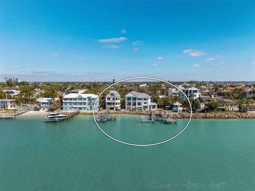 Tucked on the coveted north end of Siesta Key, this extraordinary double-lot point estate is positioned at the tip of a protected peninsula, offering panoramic water views and unforgettable sunsets. Surrounded by water and set directly across from protected parkland, the setting feels like your own private island. The property features three separate structures: a main residence, a guest house, and a separate waterfront cabana with bath. In total, the compound offers six bedrooms and six bathrooms, with gourmet kitchens in both the main house and guest house — each outfitted with high-end appliances throughout — ideal for multigenerational living, guest accommodations, or an exceptional private retreat. Throughout both residences, the finish detail is exceptional. Designer-selected materials create a cohesive and elevated aesthetic carried seamlessly across the entire compound. Custom wood flooring with intricate stone inlays, handcrafted stairwells featuring wood and stone risers, extensive crown molding, and refined architectural millwork highlight the level of craftsmanship invested in every space. Specialty stonework and thoughtfully curated finishes blend warmth with sophistication, creating interiors that feel timeless, substantial, and unmistakably high-end. Outdoor living is nothing short of spectacular. A dramatic infinity-edge pool with swim-assist system overlooks the water, enhanced by a striking waterfall feature that spills elegantly into the pool. New pool equipment (2025) supports the system. Natural rock waterfront frontage and a sculptural rock formation lead down to the shoreline, creating a one-of-a-kind coastal backdrop. Two docks serve the property — one with a double lift — offering outstanding boating access and rare protection on both sides of the point, with additional lift capacity for multiple watercraft. An outdoor shower provides added convenience after boating or swimming. Perched at the edge of the peninsula, the waterfront cabana and adjacent hot tub create a private, spa-like retreat suspended over the water — an unforgettable setting to take in sweeping sunset views. The residences were renovated separately: main house (2009) and guest house (2012). All A/C units have been renewed recently, along with the electric unit, and a new transformer (2024) services both properties. Sonos surround sound extends throughout all structures. Located on the highly desirable north end of Siesta Key, the estate offers convenient on-and-off island access while remaining just minutes from Southside Village and downtown Sarasota.