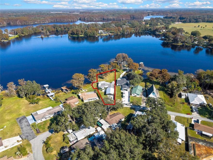 One or more photo(s) has been virtually staged. Price Improvement! Welcome to a rare and graceful lakefront residence, set on a private peninsula where tranquil waters surround the property on three sides. With wide-open views across a natural chain of lakes and a backdrop of towering cypress trees, this home offers the quiet beauty of country living paired with the comfort and dignity of a well-built, well-cared-for home.
The exterior has been thoughtfully updated with notable improvements, including a Newer Roof (2021), New Upgraded Windows, a Resurfaced Dock, a New Driveway, a New Carport, New Exterior Paint and a New Irrigation System. A huge backyard is completely fenced in with plenty of room for play. Inside, the home features New LVP in the Living room and Kitchen with Brand New Stainless Steel Appliances, a Remodeled Shower in the Primary Bathroom, Five New Individual Mini-split Units throughout—allowing each bedroom, the dining room, the living room and the office/den to have personalized climate control. It’s the kind of smart, understated luxury that simply makes life easier. Flood insurance is only $579 a year! 

Though the property feels peaceful and secluded, it remains connected to modern conveniences with public water and reliable high-speed internet. The daily comforts of home blend seamlessly with the calm of nature here. Every bedroom and the main living areas capture the lake from nearly every direction, creating spectacular views of this absolutely beautiful lake throughout the day and into the night. By the shoreline, a stone fire pit invites you to linger a little longer outdoors. It’s the kind of spot where laughter carries easily across the water. 
What truly sets this property apart is its spirit: a place that feels like home the moment you arrive. A place where neighbors still wave, and life slows down just enough to enjoy each season. The friendly neighbors hold frequent social events especially in the winter months as many of them have owned homes here for decades. The street is a loop with one way in and one way out and many walk the loop in the evening for exercise and social time! It's only 5 miles to the town of Inverness so this property strikes the perfect balance of privacy and accessibility. The Withlacoochee State Trail is here for your enjoyment of biking, running or walking. For the hiking enthusiasts,  you have popular Citrus Tract Loop A, Whispering Pines City Park: Yellow Trail, Citrus Tract Loop D, Sandhill Loop, and Floral Park! There is also worth mentioning Potts Preserve, Flying Eagle Preserve, Fort Cooper State Park, Half Moon WMA, Citrus WMA, Withlacoochee State Forest, Whispering Pines City Park, Crystal River and Rainbow River! There is just so much nature to enjoy! 
Properties of this caliber, with this setting and value, are seldom found—particularly lakefront homes of this kind. This is a chance to own not just a home, but a lifestyle that is fast disappearing: peaceful, welcoming, and serene. 

Come see for yourself. You may find that you’ve been dreaming of this place for a very long time.