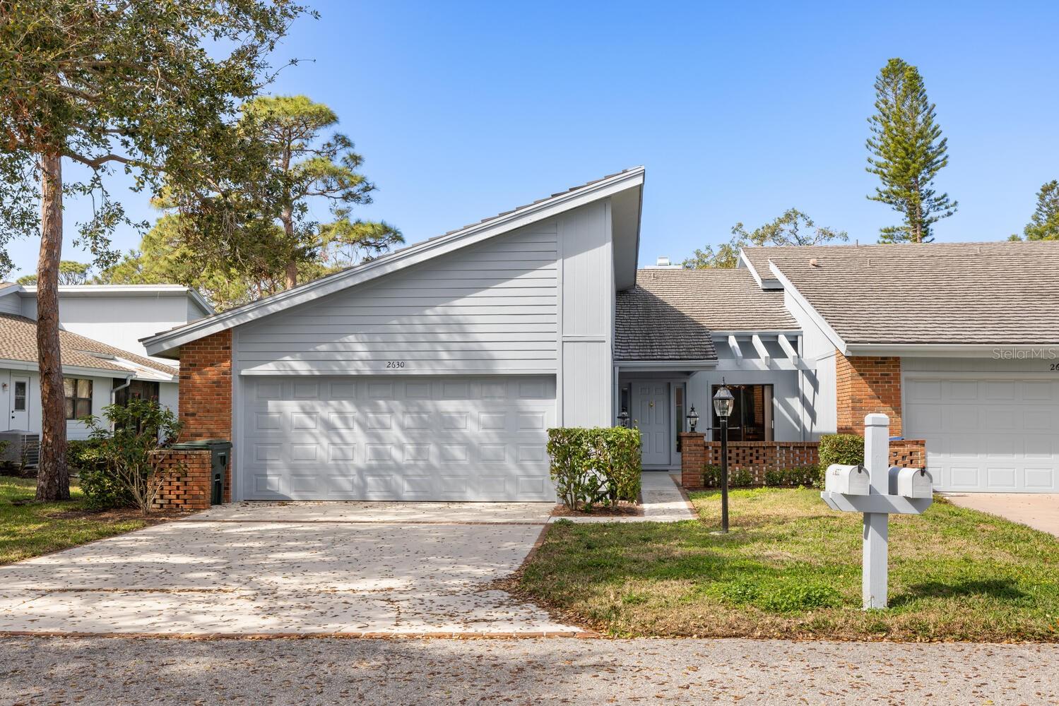 Experience the perfect blend of comfort and convenience in this spacious villa, offering nearly 2,000 square feet of thoughtfully designed living space. Nestled within the gated community of Woodbridge Estates, this home provides a serene and private retreat while being just moments from all that Sarasota has to offer. With 2 bedrooms, 2.5 baths, plus a versatile den, this villa lives like a single-family home. The open-concept kitchen, dining, and living area is ideal for entertaining, featuring a stunning floor-to-ceiling wood-burning fireplace that adds warmth and character. Recent updates include fresh interior and garage paint, an upgraded paver front patio, and stylish new window treatments throughout. Step outside to your private backyard with a screened porch, perfect for enjoying Sarasota's beautiful weather. The community is surrounded by majestic oak trees and lush vegetation, creating a peaceful and picturesque setting. Enjoy the ease of maintenance-free living in a gated community with a prime location. Whether you're looking for a seasonal retreat or a year-round home, this villa is a rare find in the heart of Sarasota.