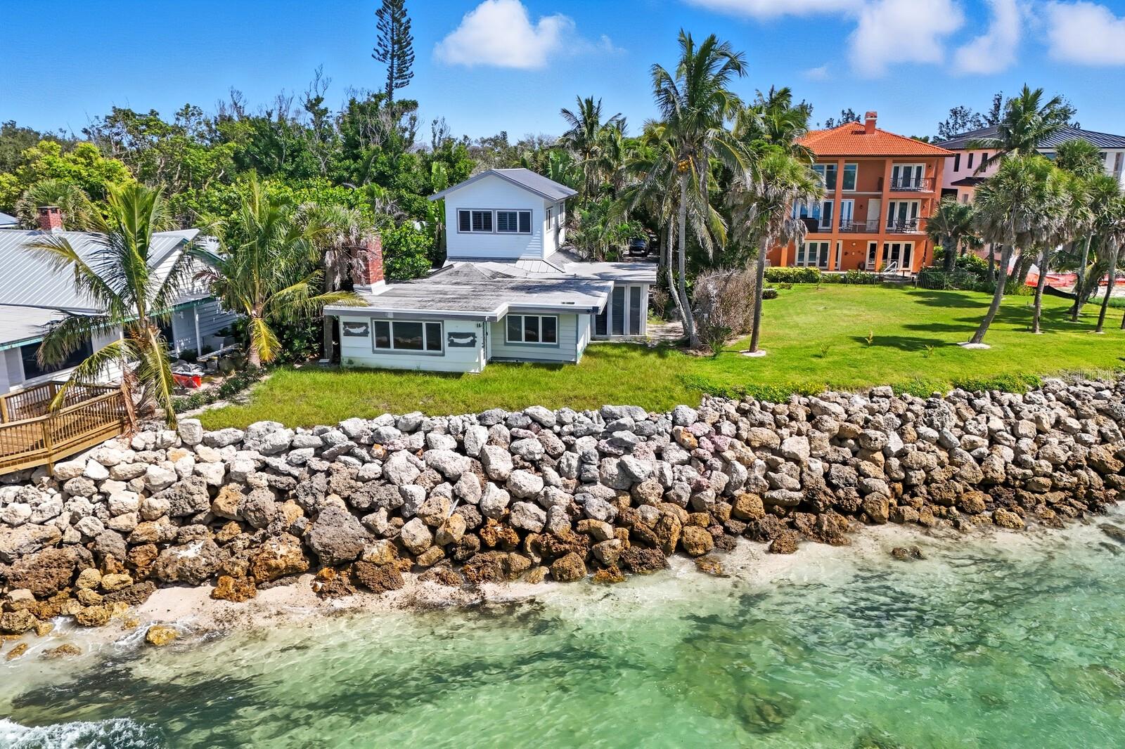 A rare Gulf-front property on Siesta Key’s legendary Point of Rocks—one of Sarasota’s most coveted and geologically unique coastal settings. Perched above the shoreline on ancient limestone formations estimated to be over 3,000 years old, this elevated homesite captures breathtaking, unobstructed views of the Gulf and spectacular nightly sunsets. Set on over one-third of an acre, the existing structure features 4 bedrooms and 4 bathrooms across a spacious split-level design with multiple indoor and outdoor living areas with flexible layouts—perfect for entertaining or relaxing in total privacy. The surrounding waters are alive with sea life and ideal for swimming, snorkeling, kayaking, or paddleboarding right from your backyard. What truly sets this property apart is its existing building footprint—a rare advantage that may allow rebuilding much closer to the water than current regulations permit for new construction. This positioning maximizes the site’s potential and preserves unmatched Gulf views. Whether you renovate, expand, or create a modern coastal retreat within the footprint, the possibilities are extraordinary. With such a large private setting, an entirely new estate could easily be designed. Just a short stroll, golf cart, or bike ride brings you to Crescent Beach and the vibrant shops and restaurants of Crescent Village. With its rare proximity to the Gulf, elevated Point of Rocks location, and limitless potential, this is one of Sarasota’s most unique and coveted Gulf-front offerings.