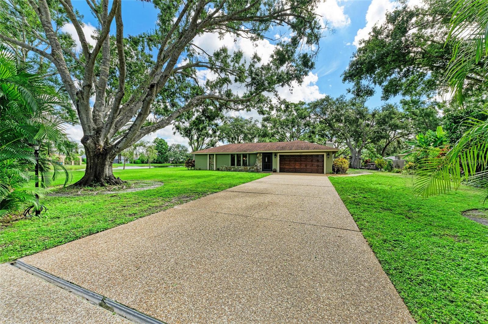 Imagine yourself living on a rare, picturesque waterfront homesite wrapped in water on two sides, on over half an acre (30,060 SF) adorned by majestic oak trees, graceful areca palms, and lush tropical landscaping, all in a prime Sarasota location just minutes from everything. Extensively and beautifully updated, this 3-bedroom home offers flexible living spaces, including a spacious living room with three large windows flowing to a formal dining area with lovely grounds views and pocket sliders to the lanai. The updated chef’s kitchen is a true delight with soft-close custom cabinetry, gorgeous granite countertops, newer stainless-steel appliances including a beverage refrigerator, under-cabinet lighting, an open connection to the living room featuring a breakfast bar, and a charming pass-through window to the lanai—perfect for indoor-outdoor entertaining. The expansive family room radiates warmth and charm with a wood beam on the vaulted ceiling, anchored by a striking wood-burning fireplace framed by two bright windows, plenty of room to add breakfast table and pocket sliders that open to an L-shaped lanai showcasing serene water views from multiple angles. From the lanai you can access the guest bathroom and is decorated with striking brick pavers. Nearly every room enjoys glimpses of the sparkling waterfront backdrop and lush greenery. The split primary suite offers two closets and an updated bath, while two guest bedrooms, a remodeled bath, and a custom laundry room with plenty of storage are privately tucked behind a barn door for maximum comfort and privacy. One of the guest bedrooms is being used as an office and desk portion can be easily removed. Other conveniences include tile throughout, all hanging TV’s are included, county water and sewer, and propane gas is connected to stove and hookup for an outdoor grill. Outdoor living shines with a firepit, adorable concrete table and benches for morning coffee or sunset gatherings, and an impressive storage shed with a newer roof—perfect for storing tools, toys, or transforming into your dream workshop or hobby space. Plus, there’s ample room to add your dream pool, park your boat or RV, and host unforgettable events. With no HOA or CDD fees, no flood zone, and unmatched privacy, this is a rare opportunity to own a stunning, move-in-ready waterfront home on an estate-sized parcel in one of Sarasota’s most sought-after locations with the convenience of being only 5.5 miles from award-winning Siesta Key Beach, minutes to I-75, vibrant downtown Sarasota, top shopping, dining, premier schools, Legacy Trail and so much more!