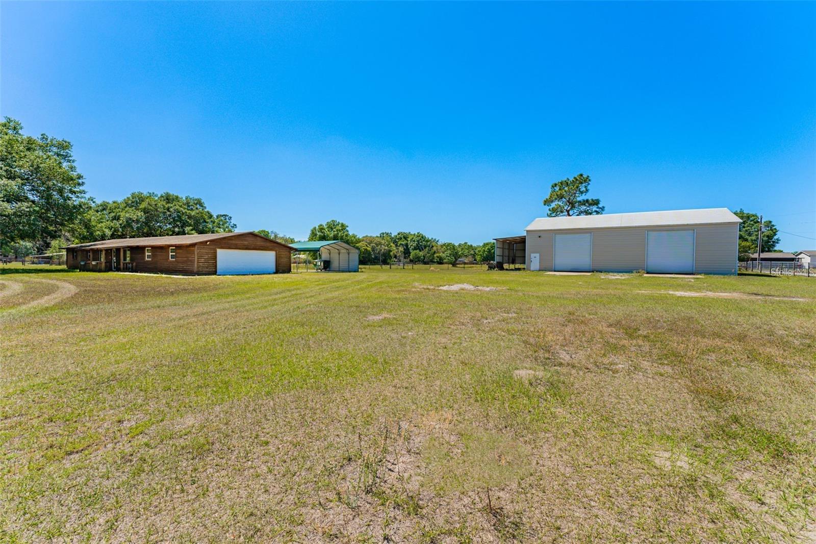 RARE OPPORTUNITY!!! 3 Bedroom plus office, 2 bath home with HUGE DETACHED 2400sqft SHOP! GARAGE CAN PARK 6+ CARS in addition to the 3 Car attached garage!!!! This type of property is rarely available as a rental. This Zephyrhills property sits on 2.2 acres with a fenced yard. Home features 3 bedrooms, 2 baths, additional family room and bonus room with AC in the garage. Kitchen has been completely remodeled with granite countertops. Laundry room in hallway, washer and dryer included. Enjoy your morning coffee or outdoor grilling from the 16x20’ Screened in Lanai 3-car attached garage. 2 car side entry garage door and 3rd garage door entry from the rear. Perfect for additional ATV, Golf Cart, Lawn equipment etc. Home and the shop are set up with connections for Generators and the home has an RV connection as well. Now for the rare opportunity for the enthusiast, gearhead, car guy/girl or anyone with lots of toys! The HUGE detached 2400sq/ft workshop (40x60) on a poured concrete slab. It was built with 22ft Center height ceilings, 16ft eves and an insulated metal roofing system. There are 3 bay doors, two 14ft in the front and one 12ft in the rear. Each is also complete with poured parking pads outside of the bays as you enter. Inside is complete with an 8000 lb. lift with and an added Gantry complete with 2000 lb. hoist and chain, and air compressor to be used by the tenant if so desired. Please see additional agreement/addendum regarding use of lift. The shop has multiple 220v outlets on almost every wall. Its 2 phase for welders etc. and a 3-phase inverter can be easily added to run larger draw equipment such as Mills, Lathes, to name a couple. Also included are a few tables, one is a large steel table. The shop has a 10X40 loft, small office, and ½ bath. There is also an 8x25 enclosure with a large steel swing out door on the outside and the shop can be entered by a small entry door inside. There is a poured concrete air compressor pad in the rear as well. For additional covered parking, on the side of the shop is a large lean-to carport parking for boat, trailer, small RV, etc. Not quite ready to buy your BIG garage home? This is truly a great opportunity for someone looking for a home to rent! *Note* Allen road is unpaved and the home does not have a driveway but ground is very flat and smooth. Located near 54 for a quick commute to Wesley Chapel, and Tampa. Schedule your showing today!