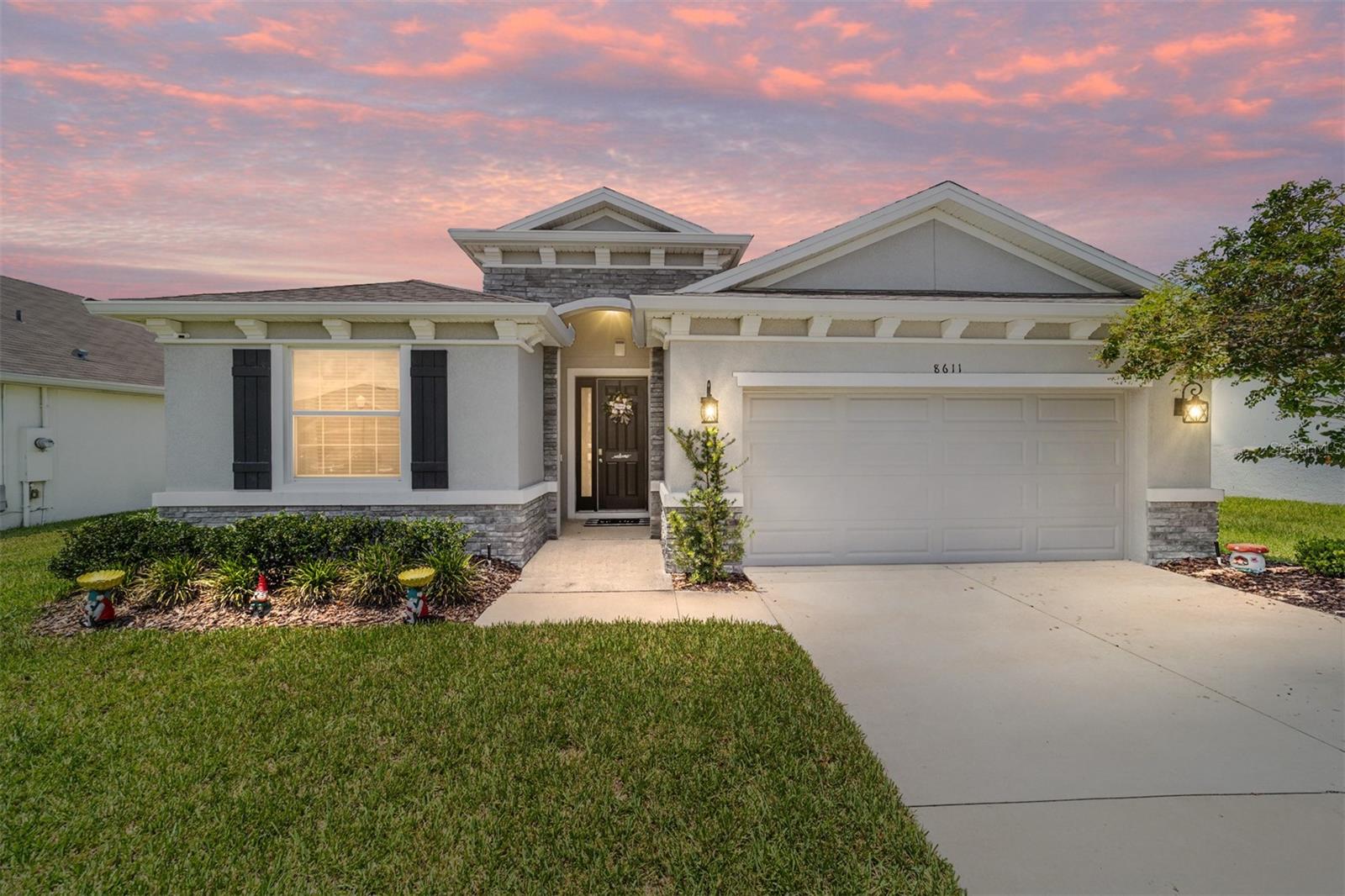 SMART HOME located Greyston Hills Phase 1 in a gated neighborhood with a pool and clubhouse. With 4 bedrooms and 2.5 baths, this DR Horton Lantana model is one-story, concrete block home that has an open concept floor plan, featuring a spacious kitchen overlooking large living and dining areas. Sliding glass doors lead to the covered lanai and the partially fenced back yard. Wainscot and wood lattice decorative woodwork throughout the house add visual appeal. Large windows throughout for natural light, upgraded ceramic tile floors, dark, solid wood cabinets throughout and granite in kitchen and baths. Kitchen has a large pantry, stainless steel dishwasher, range and microwave and fixtures and a kitchen island with breakfast bar large enough for 4 bar stools. Eat in kitchen accommodates a table for 8-10. Spacious foyer leads to the 2 front bedrooms, a full bath, laundry room with shelving and garage access and a half bath conveniently located for guests. The 4th bedroom can also be used as an office/den. and has a faux brick wall. All bedrooms have large windows complete with window treatment. Primary bedroom is located at the back of the house and has 2 walk-in closets and an ensuite bathroom with dual sinks, separate soaking tub, granite countertop, wood cabinets and lots of storage. Upgrades in the primary bedroom include panel molding and lattice woodwork decorative trim. The SMART features include smart alarm, smart doorbell with camera and sensor, smart lock, smart thermostat and smart plug. Driveway and street parking. This gated community is close to schools, restaurants, shopping, and medical. Easy access to Hwy 200 and Hwy 75.