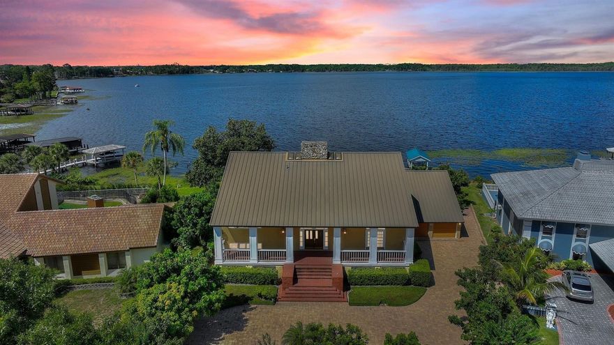 One or more photo(s) has been virtually staged. NEW PRICE!  On the Butler Chain Of Lakes!  Experience the luxury of this one-of-a-kind lakefront home nestled on Lake Tibet in the beautiful neighborhood of South Bay. Indulge in breathtaking panoramic lake views and Disney World fireworks nightly. Arguably one of the best locations on Lake Tibet with 145 feet of unobstructed frontage. Lake Tibet is 1078 acres and is part of the exclusive Butler Chain of Lakes, which includes 11 lakes in total, ensuring that the property is the perfect retreat for water enthusiasts. This traditional "Key West" style home with a metal roof and 4 levels offer a unique look here in Central Florida. This exquisite property features a private pool, summer kitchen and is perfect for outdoor living and entertaining. The expansive home boasts 4 bedrooms, and 4 bathrooms plus several extra flex spaces, and spans over 5,060 square feet. As you enter the over 200 sq. foot rich hardwood grand entry, you are greeted with a floor-to-ceiling coquina fireplace. The heart of this home is the chef's kitchen, boasting a Mediterranean design with GE Monogram appliances, a gas stove, griddle, and grill, two ovens, a microwave, and an island. The walk-in pantry is a chef's dream, perfect for storing all your ingredients and kitchen appliances. Experience a massive multi-level master bedroom with a fireplace, a walk-in closet, and additional workout/office space on the second floor. Travertine floors, new carpet, and new paint are just a sliver of the upgrades this home conveys. The oversized 2-car garage includes a private, 250+ square ft air-conditioned bonus room with cedar ceilings and walls.  This property has a ton of storage with "secret" rooms and alcoves. Use your creative imagination (and binging HGTV) and dream up the endless possibilities to make this property your own. The South Bay community adjoins the Bay Hill Country Club where you can become a member and enjoy golf, tennis, pickleball, swimming, a marina, tons of activities, and 3 on-site restaurants. South Bay offers its own host of amenities including a newly renovated tennis court, a community dock on Lake Tibet, a playground, and child-friendly activities several times per year. Excellent schools and minutes from the famous Sand Lake Restaurant Row. Don't miss out on this incredible opportunity to own a lakefront home on the Butler Chain of Lakes. Consider remodeling or building your dream home in this amazing community!.