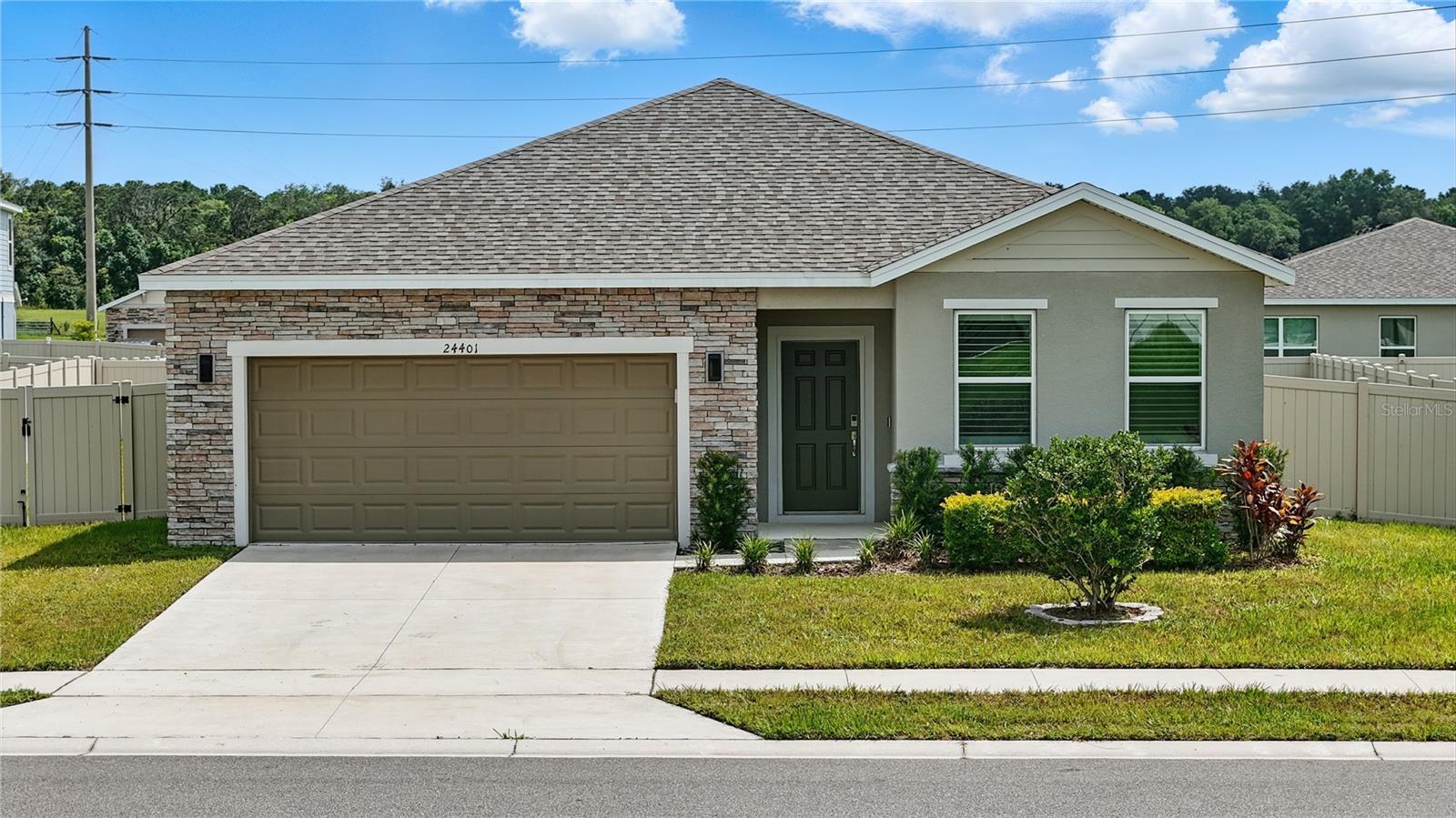 Price adjusted to better reflect current market conditions and to attract the right buyer. Welcome to 24401 Sunnys Halo Way, a meticulously maintained and beautifully upgraded 5-bedroom home, built in 2023 by D.R. Horton. Offering approximately $30,000 in thoughtful enhancements, this home is the perfect blend of new construction convenience and move-in-ready comfort, no builder punch list needed.
Upon entry, you're greeted by a versatile front room, classified as a bedroom, but ideally suited as a home office, playroom, or flex space complete with double doors for added privacy.
Throughout the living areas and bathrooms, you'll find tile flooring, while all five bedrooms are finished with a soft, light gray carpet. Shutters have been added to every window, enhancing both style and energy efficiency.
At the heart of the home is an open-concept kitchen and living room featuring stainless steel appliances (refrigerator, dishwasher, stove, and microwave), white cabinetry, modern black hardware, and a walk-in pantry. The upgraded kitchen sink includes a standard faucet, an integrated soap dispenser, and a separate tankless reverse osmosis drinking water tap. The living room is bright and airy, complete with a ceiling fan and sliding glass doors that lead to the rear patio.
The spacious primary suite includes dual windows, a walk-in closet, and an ensuite bath with a dual-sink vanity, walk-in shower, linen closet, and private water closet. Three additional well-sized bedrooms each include ceiling fans and share a second full bathroom featuring a dual vanity and shower/tub combination. All bathrooms include upgraded shower heads and sealed wet areas for added durability and protection.
The laundry room provides interior access to the attached two-car garage, which has been upgraded with ceiling-mounted storage racks, a brand-new water softener system, and an epoxy-coated floor for a clean, finished look.
Outside, enjoy a generous wraparound yard with newly planted trees, full perimeter fencing, and outdoor lighting. An additional enclosed area is currently used as a secure dog run, and a small storage unit is included for extra convenience.
This home is a rare opportunity to enjoy all the perks of a new build, plus custom upgrades that enhance everyday living. Nestled in the charming community of Sorrento, this property offers a peaceful, semi-rural setting while still being conveniently connected to major amenities. Located in Lake County, Sorrento is known for its scenic beauty, rolling hills, and laid-back lifestyle, perfect for those looking to escape the hustle without sacrificing access to key destinations.