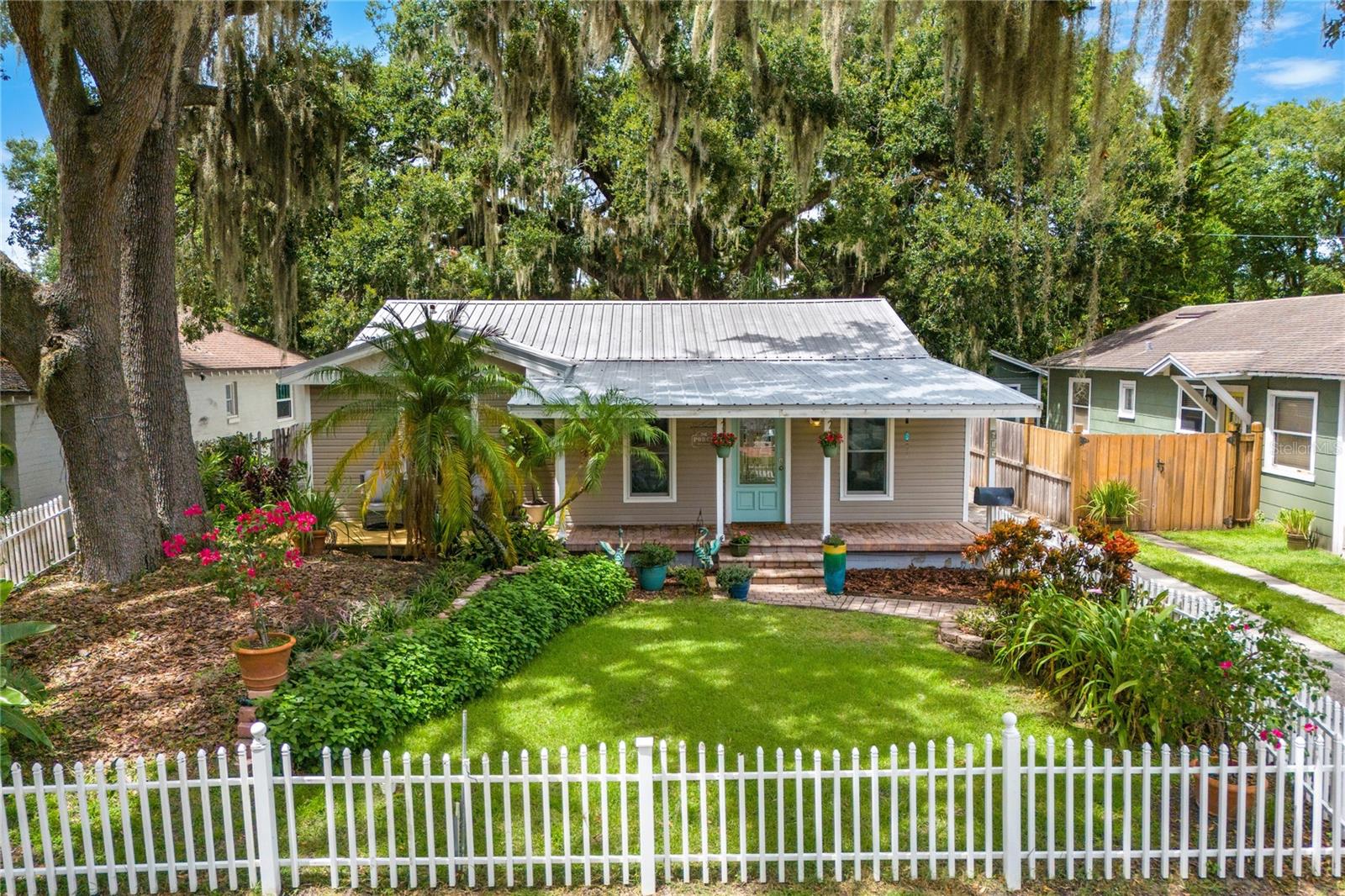 This home isn’t just close to College Park’s vibrant core, it’s practically part of it, yet tucked back on a quieter lane that gives you peace without sacrificing proximity. Beyond the white picket fence, a meticulously landscaped yard frames a storybook front porch, the perfect stage for slow mornings with coffee or lingering evenings with a glass of wine.
Inside, a light-filled Florida room welcomes you with versatility,ideal as a home office, playroom, or creative space. The oversized family room flows effortlessly into the freshly updated kitchen and dining area, where custom cabinetry (complete with spice rack pull-outs), a farmhouse sink, and abundant counter space make cooking and gathering a joy. Indoor laundry? Yes, and with room to spare. Updated windows flood the home with natural light, while three spacious bedrooms and a beautifully remodeled bath complete the comfortable, open layout.
Step out back to your private retreat: a vaulted, screened-in patio that invites all-season entertaining, plus a pergola-covered swim spa. A hybrid between a pool(ability to swim in place against a current) and a hot tub, perfect for low-impact exercise, cooling off in summer, or enjoying a warm soak under the stars. Two new sheds offer generous storage, and there’s still plenty of backyard left for play, gardening, or pets.
Major updates include a new metal roof with transferable warranty, updated plumbing and electrical, some motorized blinds and a transferrable home warranty for peace of mind. Zoned R-2, the property opens the door to future possibilities.
Location, space, and amenities like this don’t come along often in College Park, especially all in one package!! Consider this your sign to run, not walk.