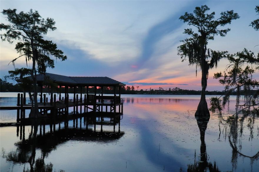 Welcome to the captivating beauty and serenity of Lake Whippoorwill, where a vibrant rural community merges seamlessly with the heart of Lake Nona without the burden of an HOA. Prepare to be enchanted by this exquisite gentleman's estate, nestled on 5.04 acres of land, offering a lifestyle of luxury and tranquility.
Driving down the long driveway toward the house, a profound sense of peace washes over you, gently dissolving the stress and demands of the day, making way for quiet contemplation and serenity. Yet, the conveniences and amenities of city life await just moments away on Narcoossee Road, with Lake Nona, Medical City, and the MCO airport within immediate proximity. 
Indulge in leisurely hours basking in the warmth of the sun, taking refreshing dips in the pool, or casting your fishing line from the dock, immersing yourself in the peaceful rhythm of the lake. The custom home affords stunning water views and picturesque sunsets, enveloping you in a sense of calmness and natural beauty.
Beyond the main residence, two acres of land near the road present an opportunity to build a guest or family house. Alternatively, the land can be divided and sold separately, offering flexibility and potential for investment. 
At the heart of the property lies a large detached garage workshop, providing a haven for storage, leisure, activities, a dedicated workout space, or a canvas for your imagination to run wild. Upstairs, the garage comes with a den/bonus area with its own bedroom and half bath on the lower level.
The remarkable residence boasts 6 beds and 5.5 baths, an intelligently designed split home, and a 3-car attached garage, ensuring ample space for vehicles and storage needs. A stunning house to entertain or grow a family. The master bedroom boasts an oversized walk-in closet, dual bath vanities, and direct pool area access. Ideal for families or those seeking more space, the home features a Jack and Jill layout, with each additional bedroom generously proportioned and connected to a full bath, ensuring comfort and privacy for family members or guests. Ascend to the upstairs bonus room, complete with its own bathroom and den, providing a versatile space for entertainment or relaxation.
The dock serves as a gateway to the wonders of lake life in Florida. Immerse yourself in boating and jet skiing with ample shelter for a boat and two jet skis, ensuring every adventure on the water is within reach.
This haven of harmony and privacy also provides a safe and open space for your beloved four-legged friends and children to roam freely in the yard. 
Don't let this rare opportunity slip away - seize the chance to own one of the limited lakefront properties in this highly sought-after area.