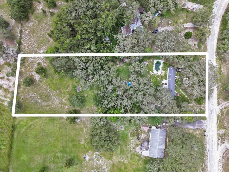 Come view this 1.33 Acre property with an  inground Pool. Impact fees paid that saves $25,000 when building new house
or modular home on property. Inground pool needs some repair. Trailer is a 1997 3/2 with 1216 SF keep or remove needs work. Has detached shed/Workshop. Lots of potential in this property. Great location; 15 minutes from Parkway yet nice and quiet on a dead end road.