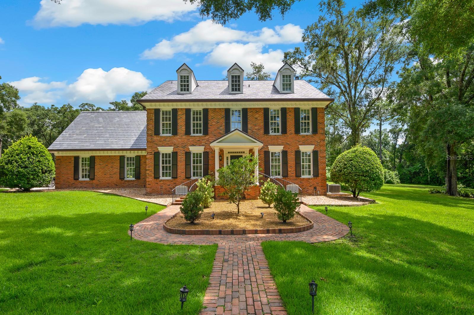 Timeless Luxury in the Heart of Gainesville — Inspired by the Davenport House!
Welcome to this breathtaking three-story luxury estate nestled on just under 10 private acres in the charming town of Gainesville. Perched at the top of a rolling hill and inspired by the iconic architecture of the Davenport Mansion, this one-of-a-kind home offers elegance, character, and space designed for both entertaining and peaceful living.
From the moment you turn onto the long, winding driveway, you're greeted with a sense of grandeur. A beautiful flow through the grand entrance with spacious rooms open and bright with so much natural light. The gorgeous kitchen has it all- Viking appliances, marble finishes, with beautiful views. The home boasts 4 spacious bedrooms and 3 full bathrooms on the second floor, with thoughtful design details throughout. On the third floor, a fully functioning apartment studio offers the perfect retreat for guests, extended family, or creative studio space with living room, a fully updated bathroom.
A separate, oversized 3-car garage includes its own beautiful and fully equipped studio apartment upstairs— ideal for additional income or private quarters. Outdoors, enjoy the resort-style brick paver pool deck with oversized cabana bar, complete with TV, wet bar, and grilling area — perfect for hosting unforgettable Saturday barbecues with friends and family. For equestrian enthusiasts, the property features a sectioned pasture with fencing, ready for horses. Inside and out, this home is filled with charm and modern comforts — creating the perfect blend of classic design and contemporary ease. Whether you're looking for a forever family estate, a private retreat, or a showpiece for entertaining, this remarkable property offers the privacy, space, and timeless style you've been searching for.