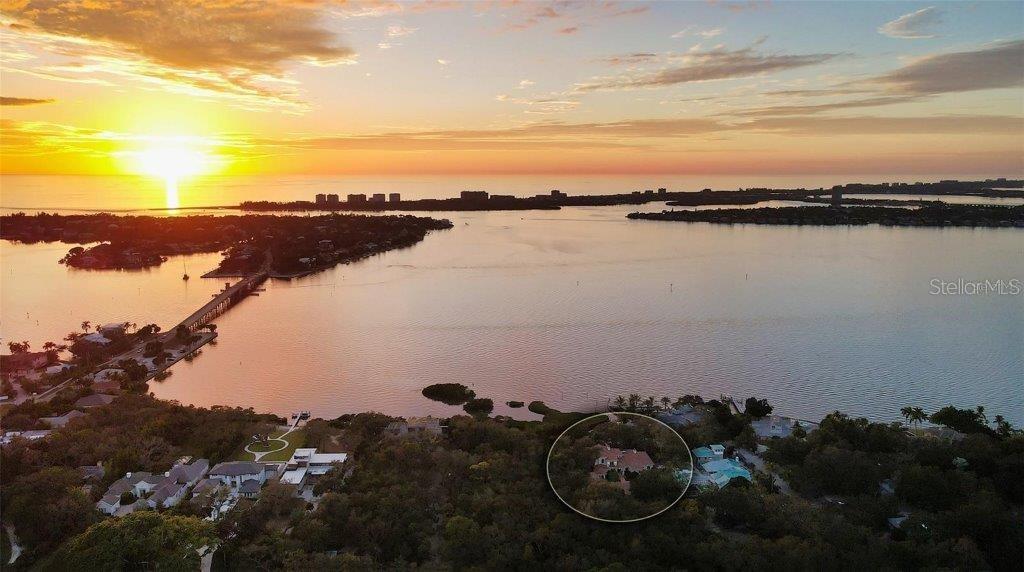 Owner has reduced price to a point creating an exciting opportunity to own one of Sarasota’s great estates. Discover the perfect blend of elegance and privacy on this 1.6-acre estate nestled within Cherokee Park, one of the most sought-after mainland neighborhoods in Sarasota. Tucked away on a small street at the end of Southwest Drive, this double lot estate is in a beautiful setting unlike any other property along the Bayfront. With its traditional architectural style and gated entry, this home offers a serene haven away from the world. An unprecedented secret lies at your rear doorstep—an extraordinary boat basin along the bay front, dredged to accommodate most any boat. For water enthusiasts, this is a dream come true with two boat lifts (10,000 lb. and 16,000 lb. capacities). Your sanctuary is set back from the shoreline, ensuring complete seclusion and uninterrupted peace as you revel in the tranquil surroundings. A masterpiece by design, this architectural gem was designed by the esteemed architect, Clifford Scholtz and brought to life by the renowned Rich Perrone of Perrone Construction. Every detail reflects their commitment to quality and craftsmanship. Step inside to a meticulously planned layout, featuring a great floor plan with an elaborate primary suite and exercise room located on the main level. For those who love to entertain, the party-scale media room is the ultimate experience complete with a bar and multiple TVs for the sports enthusiast. Five-bedroom suites await your personal touch. This home also includes a Mahogany wood paneled office, a formal dining room, and a captivating saltwater fish tank that serves as the focal point of the kitchen and breakfast room. Covered patios and loggias extend from the most major rooms, creating ideal space for relaxation and enjoyment. A detached oversized 3 car garage with a covered walkway to the main residence has excessive space for storage or workshop activity. Step into the expanded screened outdoor room, complete with double TVs and the largest Wolf outdoor gas grill available and a Subzero refrigerator. The Chicago brick flooring adds style and durability. The free form dream pool, paved in Chicago brick, is a haven for leisure and outdoor entertainment. Subdivide the lot for an additional building lot that has it’s own private gated entry in place or use a portion of the expansive lotto build your guest house, tennis court, or pickleball court – the possibilities are endless. The home is equipped with a brand-new whole house generator. Specimen trees, lush landscaping, and ancient oaks frame the home, creating a stunning natural backdrop for your daily life. Your dream home awaits, a harmonious blend of luxury and practicality. Don’t miss the opportunity to make it yours. Schedule your viewing today and step into a world of timeless elegance and exceptional living.