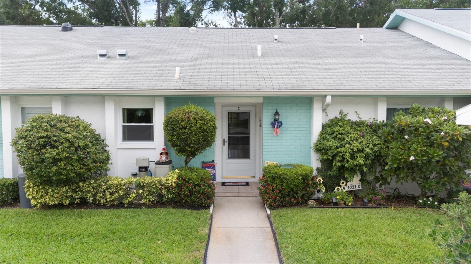 Nestled in the highly sought-after 55+ Greenview Villas of Highland Lakes, this lovingly maintained 2-bedroom, 2-bathroom villa with a one-car garage is ready for its new owner. This charming home is full of warmth, personality, and thoughtful updates, offering comfortable living both inside and out. Curb appeal meets coastal charm with a freshly manicured lawn, a crisp white garage, and pops of vibrant color from blooming flowers and potted palms. Step inside to discover a spacious living and dining area with vaulted ceilings and double-paned windows that allow an abundance of natural light. The soft coastal palette and tasteful nautical touches throughout create a relaxed, vacation-like vibe. The modern kitchen boasts newer appliances, updated white cabinetry that provides ample storage, recessed lighting, and stunning granite countertops paired beautifully with a glass tile backsplash. The living area flows seamlessly into a private enclosed Florida room vented with air-conditioning, featuring floor to ceiling windows overlooking the beautifully landscaped green space, ideal for both entertaining and relaxation. The spacious master bedroom complete with a walk-in closet and en-suite, and has direct access to the Florida room and offers plenty of space for a king-sized bed and sitting area. The guest bathroom is whimsical and fun, adorned with a colorful aquatic theme that will make any visitor smile. This home includes a dedicated laundry room with storage cabinets and utility sink, a spacious guest bedroom, a water softener, a new water heater, AC and ductwork(2019), roof (2018), tile flooring throughout, and a garage with brand new siding, epoxy flooring and shelving. Greenview Villas offers its own community pool, while Highland Lakes features three beautiful Executive 9-hole golf courses, a Clubhouse with a heated Olympic-sized pool and spa, tennis, bocce, pickleball, shuffleboard, and fitness classes. There are opportunities to connect with other residents through clubs and social events. Additionally, you can take a refreshing swim at the Lodge on Lake Tarpon or enjoy a tour on one of the Pontoon Touring Boats. Don't miss out – schedule your appointment today!
