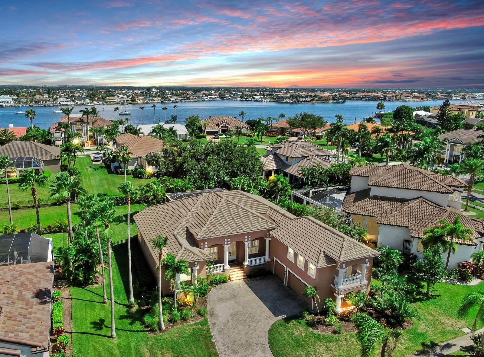 Experience refined elegance and welcoming living in a 24-hour manned, gated enclave directly on Tampa Bay. This upscale residence pairs sophisticated design with homelike comfort and offers resort-style amenities just steps from your door. Gorgeous landscaping, a paver driveway, and striking curb appeal greet you as you arrive. A grand entry through double French doors opens to a bright foyer with high ceilings. The kitchen features maple cabinetry, stone counters, a large island, an oversized pantry, and a breakfast bar. Living spaces offer pool and private yard views from multiple angles, and new flooring throughout—including brand-new carpeting upstairs and updated flooring downstairs—enhances the home's fresh feel. The downstairs primary suite showcases a large garden tub, a walk-in shower, dual vanities, an expansive walk-in closet, and slider doors opening to a private lanai. Plantation shutters prevail throughout most of the home, boosting natural light and privacy. Upstairs you can enjoy a large bonus room with wet bar and a spacious guest suite with balcony making this the perfect space for guests. Recent Upgrades and Improvements include a brand-new tiled roof completed on July 15, 2025, and a main HVAC (Trane) replacement in June 2021 with custom aluminum brackets/stands installed to resist rust and rot. A water softener was added in May 2025, and the pool was resurfaced with a saltwater conversion in June 2021. Landscaping features a seven zone well ran sprinkler system for low cost water solution. Outdoor and Community Amenities offer a private pool and expansive lanai set within a landscaped yard ideal for seamless indoor–outdoor living. The community features a bay-front clubhouse and tennis courts, plus a private marina with slips potential opportunity to rent or purchase. A private beach and jetty provide access to Tampa Bay’s open waters. Additional Details include fresh landscaping that enhances curb appeal and a move-in-ready home with major systems updated. The community offers 24-hour security and meticulous maintenance within a prestigious, upscale setting. This residence embodies a rare blend of luxury, comfort, and water-side living within a secure, welcoming neighborhood. For more information or to schedule a tour, call today.