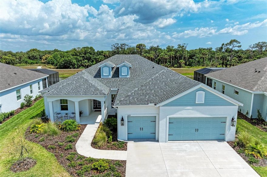 A rare opportunity to own a NEVER LIVED IN, designer-upgraded home on one of Canoe Creek’s premier waterfront lot represents a remarkable value, offered far below original cost.  This exceptional Captiva plan provides immediate occupancy-no construction delays, long wait times, or uncertainties. As one of the final homes in the Coastal Collection for this phase, this home offers the most sought-after options, like no other on the market featuring IMPACT WINDOWS & SLIDERS, EXTENDED LANAI OPTION WITH AN OUTDOOR KITCHEN, EXTENDED PRIMARY CLOSET OPTION, TWO OFFICES, SHOWSTOPPING KITCHEN AND EXTENDED 3-CAR GARAGE. Perfectly positioned with peaceful lake views, a serene preserve backdrop, and a scenic walking path with no front-facing neighbors for added privacy. A welcoming front covered porch leads into a thoughtfully designed interior featuring an elegant glass entry door. The open-concept layout is highlighted by luxury vinyl plank flooring throughout—no carpet—along with a versatile bonus room/office with double doors, another dedicated private den or office, and two generously sized guest bedrooms. One guest suite includes an en-suite bathroom, providing comfort and privacy for visitors. Crown molding and tray ceilings with refined detailing in the owner’s suite, bonus room, and great room add a sophisticated touch throughout the home. The chef’s kitchen is a true centerpiece, featuring custom double-stacked cabinetry with lighting, soft-close drawers, pull-out shelving, a custom curved hood, and a large island with decorative panels and a scratch-resistant undermount sink. High-end appliances include a five-burner Fulgar Milano gas cooktop, built-in oven, convection microwave, stainless steel dishwasher, and quartz countertops. The owner’s suite is filled with natural light and offers a spacious walk-in closet and a spa-inspired bath with a large walk-in shower, designer tilework, quartz countertops, and premium fixtures. Designed for seamless indoor-outdoor living, the extended lanai features multiple entertaining areas, access from the great room, dining room, and bonus room, and a built-in outdoor kitchen with granite countertops. There is ample space to add a private pool, making it ideal for entertaining or relaxing. Additional highlights include smart home technology, pre-wiring for a security system, wireless access point, epoxy-finished garage flooring, upgraded pantry shelving, and a spacious laundry room with upper cabinets and a laundry sink. Canoe Creek is a low-maintenance community with NO CDD fees, offering resort-style amenities including a lagoon pool and spa, fitness center, clubhouse, pickleball courts, dog park, community events, and an on-site lifestyle director. Ideally located near Lakewood Ranch, the Manatee River, Sarasota, St. Petersburg, and Tampa, with convenient access to Gamble Creek Farmers Market for fresh local offerings.