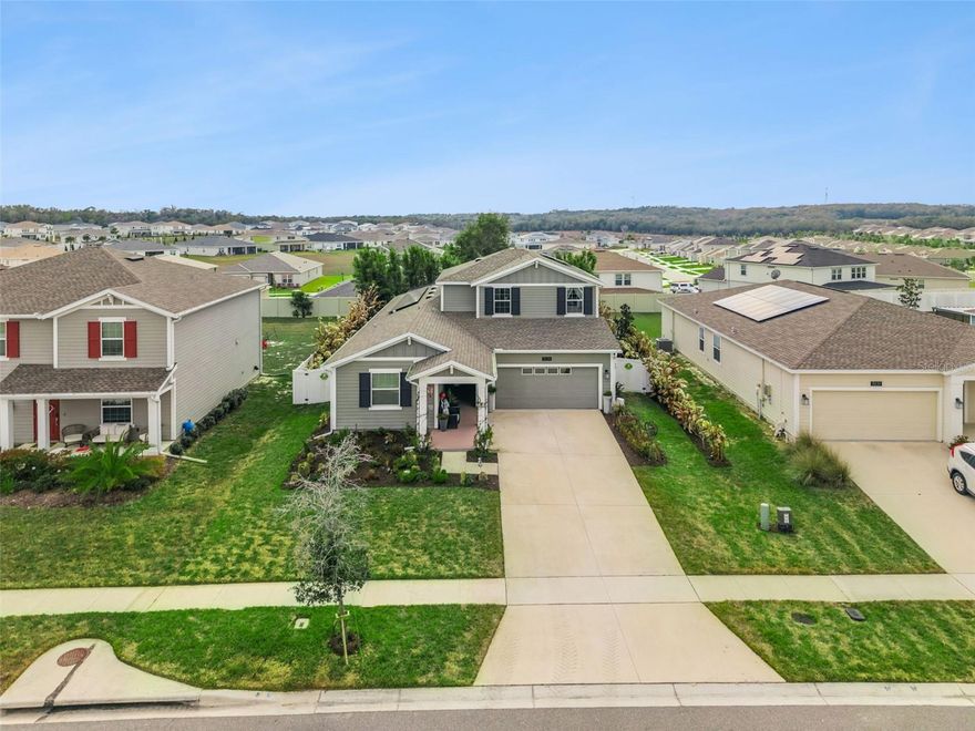 Welcome to 5125 Tanzanite Drive in Mount Dora, located in the highly sought-after, guard-gated community of Stoneybrook Hills. This MOVE-IN READY 5 BEDROOM, 4 BATH POOL HOME offers the highly desirable NEXT GEN floor plan, perfect for MULTI-GENERATIONAL LIVING or a private IN-LAW SUITE with its own PRIVATE EXTERIOR ENTRANCE, full kitchen, living room, bedroom, and full bathroom—ideal for extended family, guests, or flexible living arrangements. The PRIMARY SUITE is conveniently located on the FIRST FLOOR, along with an additional downstairs guest bedroom with its own full bath, making it perfect for a HOME OFFICE or private guest retreat. Upstairs you’ll find a spacious LOFT/BONUS ROOM plus two additional bedrooms and a full bathroom. The OPEN CONCEPT layout is enhanced by TILE FLOORING, QUARTZ COUNTERTOPS, 42-INCH CABINETS, CROWN MOLDING, and abundant natural light. Step outside to your private backyard oasis featuring a 24 x 11 POOL installed in 2022 with a beautiful WATERFALL FEATURE—perfect for enjoying Florida outdoor living year-round. Fully fenced for privacy, security, and peace of mind! The home is constructed with durable LP SmartSide siding, known for its IMPACT RESISTANCE, moisture protection, termite resistance, and LOW MAINTENANCE durability—ideal for Florida’s climate. The solar panels make this better than new home energy efficient. Stoneybrook Hills offers RESORT-STYLE AMENITIES including a community pool, splash pad, clubhouse, fitness center with child play area, basketball and tennis courts, greenspace, and 24-hour guard-gated security. Conveniently located near shopping, dining, and everyday essentials, and just 4 miles from historic downtown Mount Dora, known for its waterfront views, boutique shopping, dining, and year-round festivals. If you are searching for HOMES FOR SALE IN MOUNT DORA FL, a POOL HOME, or a NEXT GEN HOME WITH IN-LAW SUITE, this exceptional property checks every box.