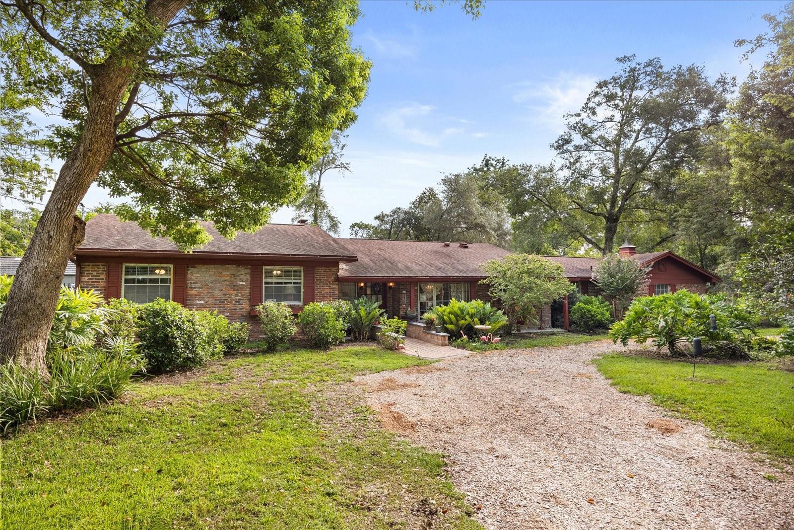 Unique retreat with a private outdoor oasis on an over half acre corner lot! This elegant home is NOT the typical cookie-cutter home you would find just anywhere. it is warm, inviting and loaded with charm! Enjoy both character and modern convenience with the multitude of updates in recent years. The spacious foyer steps into an expansive great room with a stunning wall-to-wall brick wood-burning fireplace. This impressive room has light-flooding solartube skylights and is lined with sliders that look out to the Florida Room and gorgeous backyard, which is the focal point of this beautiful home. You'll appreciate the handsome wood flooring, crown molding, built-in features and tasteful paint colors found throughout. The updated kitchen is a dream! It's features include a copper farmhouse sink, induction cooktop, full size double ovens and a wine/coffee bar with a wine fridge! Cooking exhaust fan fully vented to the outside! Just off the kitchen is a large, unique utility room/mud room with an additional pantry and access to a courtyard area adjacent to the backyard. Both baths have been renovated in recent years. The primary has a large walk-in shower and the guest bath has an attractive soaking tub. Beyond the great room is huge Florida room lined with wall to wall windows. This area is perfect for a game room or additional relaxing seating area to take in the surrounding natural beauty. The private backyard is a garden enthusiast's dream! This swoon-worthy area has newly installed pavers, multiple seating areas, a fire pit area, brick outdoor grill and garden area. A newer vinyl fence completely surrounds this triple lot yard with a private side gate for convenient access. Other updates include a large scale area of pavers (25k), all new well equipment, plumbing ('19), electrical including new service line into the house and electrical panel ('23), well, reverse osmosis water treatment system and whole house generator! NOTE that home was originally 4 bedrooms, but 4th bedroom was converted to the utility room. Can be converted back if desired! Enjoy country living just moments from everything!